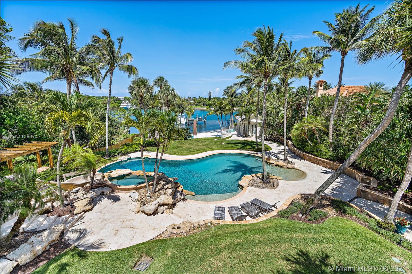 On 100 feet of blue, Intracoastal waters this plantation-style estate on 3.3 acres has 4 structures; the Residence, the Carriage House, the Guest Cottage & Poolside Cabana. Also a Pool, Tiki Hut, sandy beach, fully equipped dock and SO much more! The gate opens to an impressive winding drive, past the 4-bedroom Cottage on the right & the Carriage House on the left with living quarters above. As you enter the main residence, the charm of this Southern plantation colonial greets you with gorgeous cherry floors, formal dining & study with fireplaces, soaring ceilings, a fabulous staircase & a stately openness that is breathtaking! The living areas lead out to the loggia, a fantastic area for entertaining, overlooking the blue waters of the Intracoastal. The kitchen is strong in