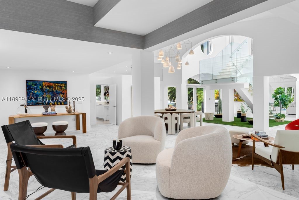 Discover contemporary elegance in this stunning 6,264 total SF waterfront residence on the coveted Coral Gables Waterway. Set on a 20,050 SF lot, this 5-bedroom, 5.5-bath masterpiece blends modern design with effortless indoor-outdoor living. Sunlit interiors flow seamlessly to serene outdoor spaces, creating a perfect balance of style and comfort. The gourmet kitchen features custom cabinetry, a striking island, and premium appliances, ideal for both everyday living and entertaining. Refined details include a grand marble staircase, impact glass, and a spacious family/game room with wine cellar and wet bar. The outdoors offer a heated saltwater pool, fire pit, summer kitchen, and private dock with boat lift. Enjoy exclusive access to the new City Park and proximity to Riviera Country Club.