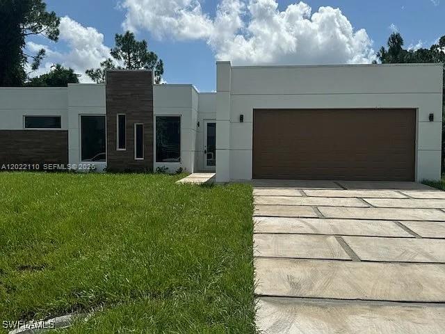 Seller financing available.  Lease option or lease purchase also available.  Custom-Built Masterpiece in Prime Lehigh Acres Location. Discover a one-of-a-kind, custom-built contemporary home featuring 3 spacious bedrooms and a luxurious master suite complete with a generous walk-in closet and a spa-inspired bathroom. The master bath offers a glass-enclosed shower and dual sinks for added convenience. An additional half-bath ensures guests are comfortably accommodated. Enjoy seamless entertaining in the open-concept living and dining area, which flows effortlessly into the chef’s kitchen. This culinary haven includes white 42? Shaker-style cabinets, high-end stainless steel appliances, and a striking waterfall quartz countertop island. Car enthusiasts and DIYers will appreciate the oversized garage with a dedicated tool room and built-in storage. Step outside to the patio, perfect for evening barbecues and stylish entertaining. Situated in a sought-after area of Lehigh Acres, this unique home provides easy access to shopping, dining, and everyday amenities. With modern design and thoughtful craftsmanship throughout, this home truly stands apart.