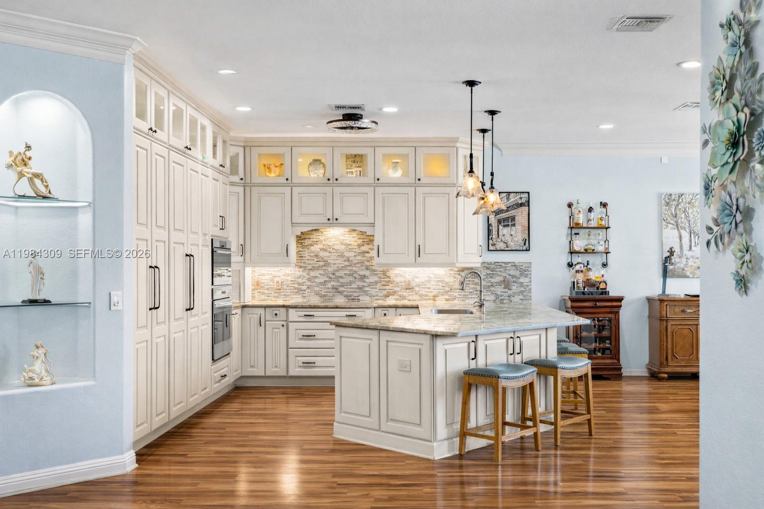 EXTRAS GALORE! This fully custom lakefront luxury home in the prestigious Herons Glen gated championship golf & country club community has been completely reimagined with over $700,000 in high-end upgrades.
Boasting 3 bedrooms plus a den (Eagle model), this 2,133 sq ft showpiece offers resort-style living with premium finishes throughout. The chef’s kitchen is a true centerpiece, featuring custom dovetailed solid birch cabinetry with soft-close hinges and pull-out shelving, expansive exotic Verde Gaya quartzite countertops, and a full Sub-Zero & Wolf appliance suite—including a steam/convection oven and induction range with concealed vent.
Spa-like bathrooms showcase high-end marble and quartzite surfaces, highlighted by the primary suite’s luxurious shower with body jets. Major structural enhancements include hurricane-impact windows and doors, a new tile roof (2020), full exterior repainting, and a whole-home water filtration system.
Step outside to experience the best of Florida living: a solar-heated saltwater pool, separate Michael Phelps swim spa with Covana automated cover, expansive panoramic screened lanai, and a fully equipped outdoor kitchen featuring a Big Green Egg. The home sits on a premium lakefront lot with stunning water views.
Herons Glen features an award-winning 18-hole championship golf course (redesigned by Ron Garl in 2021), plus a full array of amenities including clubhouse dining, fitness center, tennis, pickleball, and a vibrant social calendar—all within this beautifully maintained gated community.
This is true custom Florida luxury—move-in ready and built to impress. Schedule your private showing today!