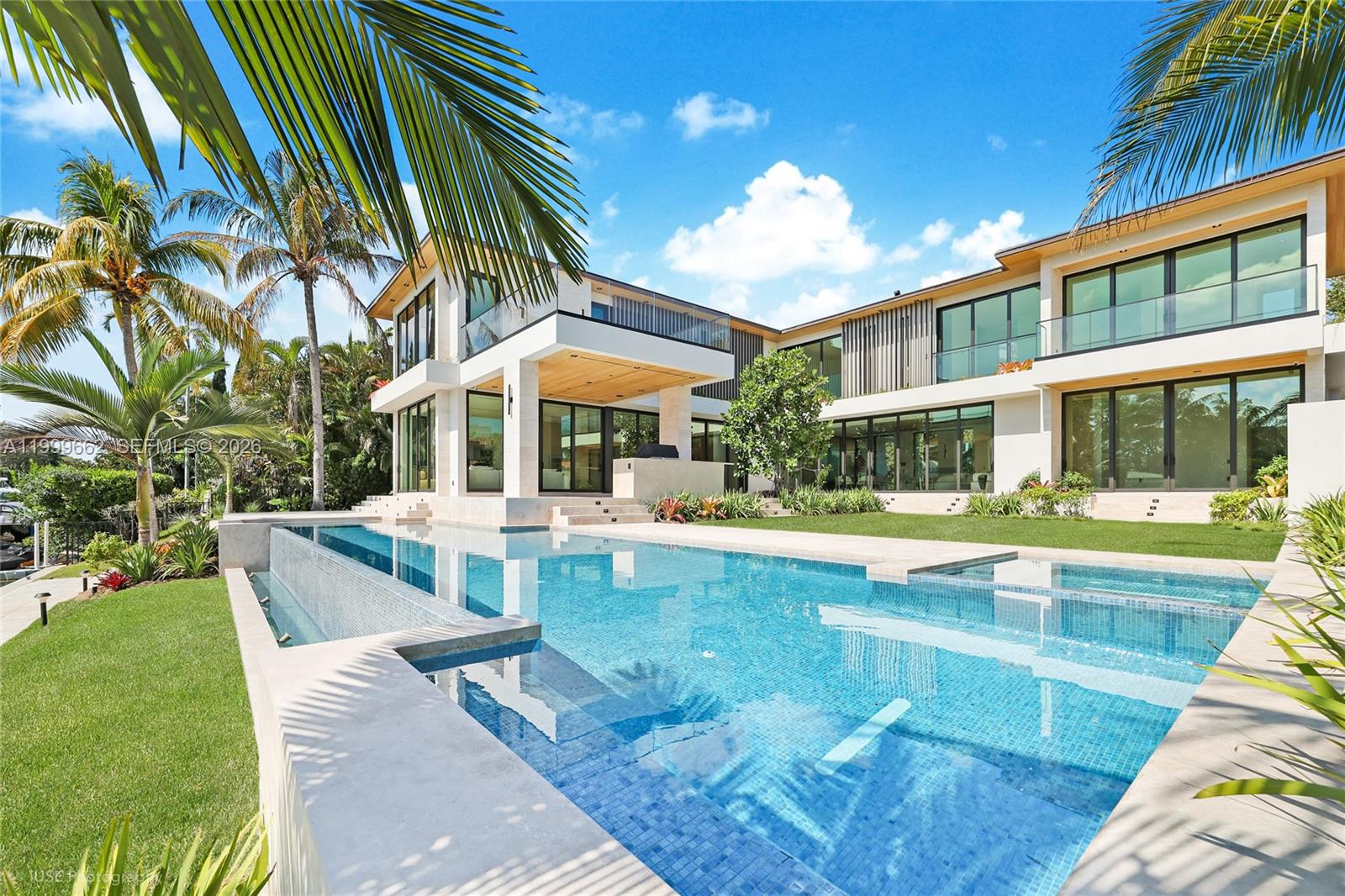 Discover the perfect blend of privacy, security, and modern sophistication in this waterfront estate within Bay Point’s exclusive gated enclave. Designed by César Molina of CMA Studio, this 6-bedroom, 6.5-bath residence offers 6,197 sq. ft. of thoughtfully curated living space. Exquisite custom millwork enhances interiors with Italian-imported MiaCucina cabinetry, kitchen, and closets, complemented by Gaggenau appliances and unique 48x48 Marble floor. A two-person elevator, full Lutron Palladiom and Control4 automation, resort-style infinity pool with waterfall, summer kitchen, and lush landscaping span 98 feet of waterfront with dock, creating a serene Miami sanctuary. The house is ready for occupancy.