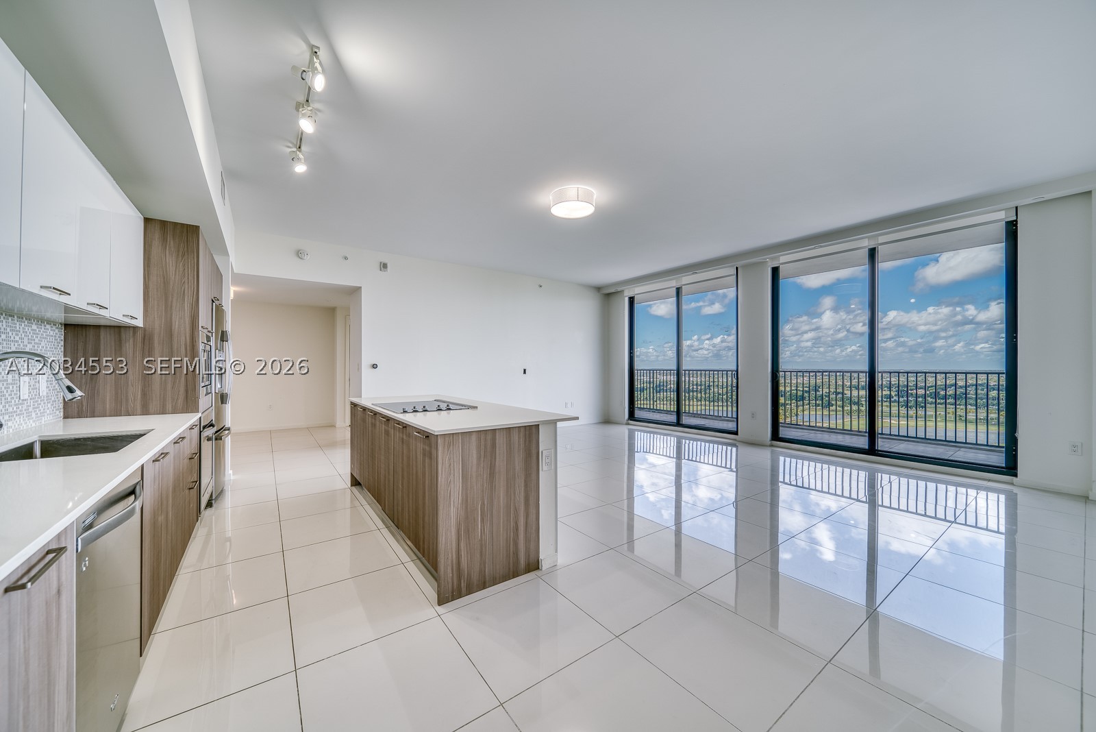 **2 Bedroom Plus Large Den** — Magnificent penthouse in Downtown Doral with uninterrupted views of the prestigious Blue Monster Golf Course. Floor-to-ceiling windows fill the residence with natural light, while a 400 SF balcony spanning the entire unit creates seamless indoor-outdoor living. Features include 2 bedrooms, 2 recently remodeled bathrooms, a large den, spacious walk-in closets, and an open kitchen with an island cooktop designed for entertaining. Includes 2 assigned parking spaces and storage. Enjoy well-maintained amenities including a pool, fitness center, and business center, all within walking distance of Downtown Doral's restaurants, shopping, and entertainment. Maintenance includes water, cable, and internet.