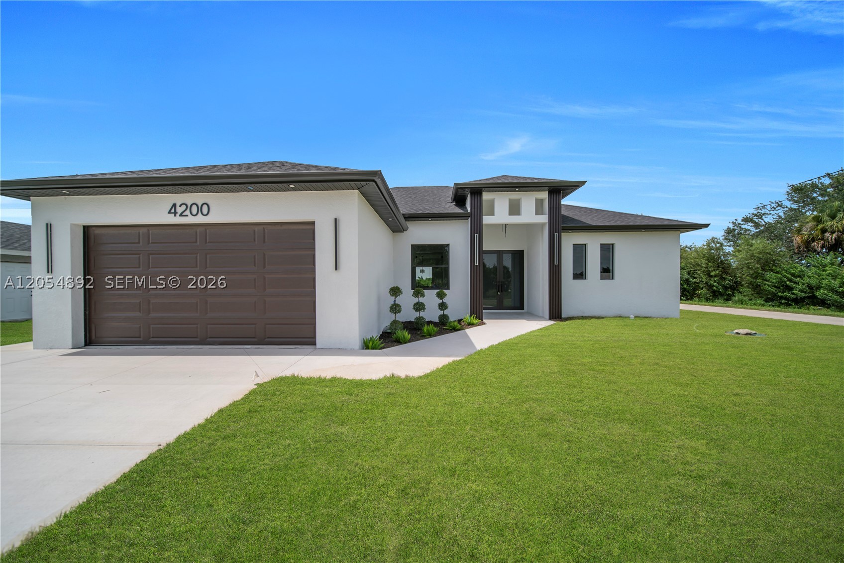 Welcome to this stunning new construction home featuring 3 bedrooms, 2 bathrooms + DEN ideal for a home office or guest room. Designed with modern style and comfort, it offers an open layout, high ceilings, impact windows and doors, and quality finishes throughout. The gourmet kitchen includes high-end appliances, double ovens, quartz countertops, and custom cabinetry. Crown molding adds elegance, while the terrace kitchen is perfect for entertaining. Conveniently located close to shopping, dining, schools, and major roads, this move-in-ready home blends luxury and convenience. Don’t miss this great opportunity! One or more photo(s) has been virtually staged, AI generated or rendered.