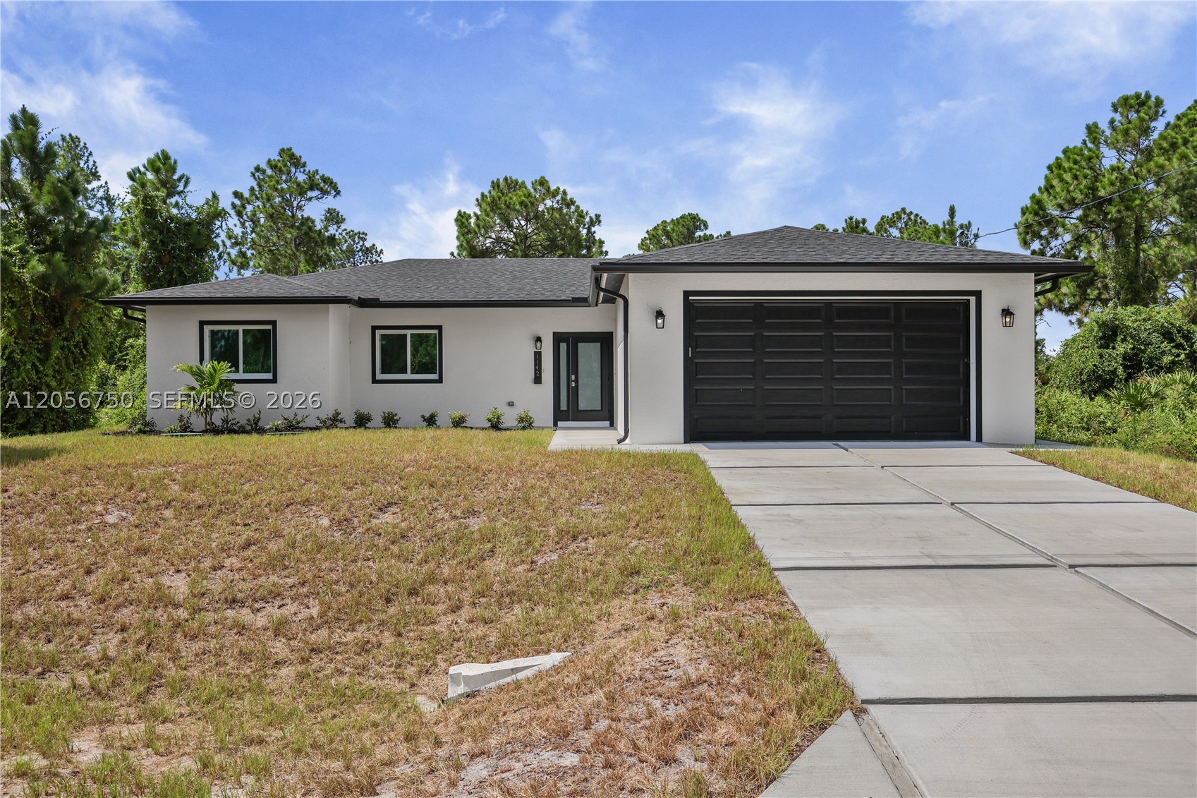 Welcome to this brand new 2026 built home offering 4 bedrooms and 3 baths (2 full, 1 half) across 1,632 sq ft of living space, set on a spacious .24 acre lot. Inside, the kitchen is a true showpiece, featuring a massive waterfall edge island, sleek white cabinetry, quartz style counters, and a full suite of stainless steel appliances including a range, dishwasher, disposal, and self cleaning oven. It opens seamlessly into the great room and dining area, all finished with elegant tile flooring throughout. The split bedroom layout offers privacy and flexibility, with a primary suite featuring a spacious walk in closet and an en suite bath with a glass enclosed shower, while the remaining bedrooms are thoughtfully separated, each with generous closet space. Additional features include an interior laundry, and a covered lanai/porch overlooking the backyard. Impact resistant doors and sliding windows, and an attached 2 car garage. Built for comfortable, low maintenance living, and located in a no subdivision setting in Southeast Lehigh Acres, this move in ready new build offers a great opportunity for buyers seeking modern construction with room to make it your own.