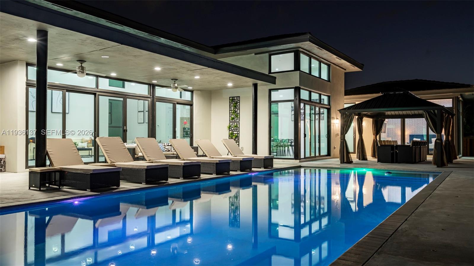 A rare opportunity to own a beautifully built 2022 estate in the highly sought-after Plantation Acres community. This expansive 8-bedroom, 7-bath residence spans approximately 7,000 sq ft and showcases impressive 15-foot vaulted ceilings, a heated pool, game room, and private home theater. Designed for both comfort and entertaining, each bedroom offers generous space, while the primary suite serves as a serene retreat. Located just minutes from Fort Lauderdale and Hollywood beaches, Sawgrass Mills, premier golf courses, and within walking distance to American Heritage School. Zoned for an equestrian-friendly lifestyle, this move-in-ready home blends luxury, privacy, and convenience in one exceptional offering.