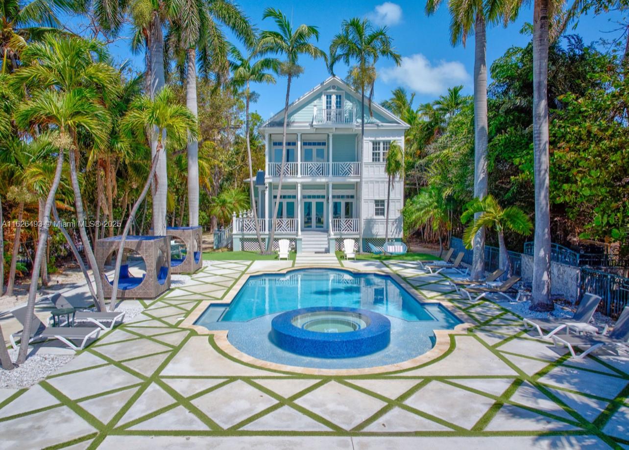 Enjoy endless ocean views and direct access to the white sandy beaches of Islamorada from this oceanfront retreat. Behind your own private gated entrance, this solid concrete block home offers four bedrooms, four full bathrooms, and a cozy loft. Inside, hardwood floors run throughout an open layout featuring a breakfast nook, dining bar, and spacious living area — ideal for entertaining. The chef's kitchen is equipped with stainless steel appliances, a gas stove, and modern finishes. The master suite includes a private balcony overlooking the updated saltwater pool and a jetted tub for ultimate relaxation. This one-of-a-kind property also allows weekly rentals, making it a strong investment in one of the Keys' most sought-after locations.