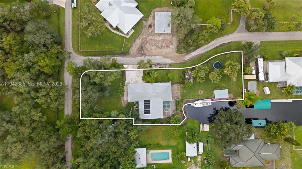 Welcome to your waterfront retreat offering lasting durability and abundant space. Built with solid concrete construction and a metal roof, this 3-bedroom, 2-bath home spans 2,014 sq. ft. and sits on a rare double lot featuring 130 feet of freshwater canal frontage with direct Gulf access. Nestled on a quiet, paved private road, the property provides exceptional privacy and a well-maintained, peaceful setting. Inside, vaulted ceilings in the living room, family room, kitchen, and primary bedroom create an open, airy feel, while the guest bedrooms feature nine-foot ceilings for added comfort. The three-car garage with eight-foot insulated doors provides plenty of room for vehicles, storage, or hobbies. The property has NEVER FLOODED! Designed for relaxation and entertaining, the outdoor living area includes a heated pool and spa, an outdoor kitchen with electric and plumbing, and a boat dock complete with seawall and cabana. Two fully fenced yards—front and back—offer ample space and privacy, beautifully complemented by a tranquil koi pond and outdoor shower. With no HOA fees, direct water access, and spacious grounds, this home combines coastal living with everyday convenience. It’s an outstanding opportunity to customize and enjoy a unique waterfront lifestyle.