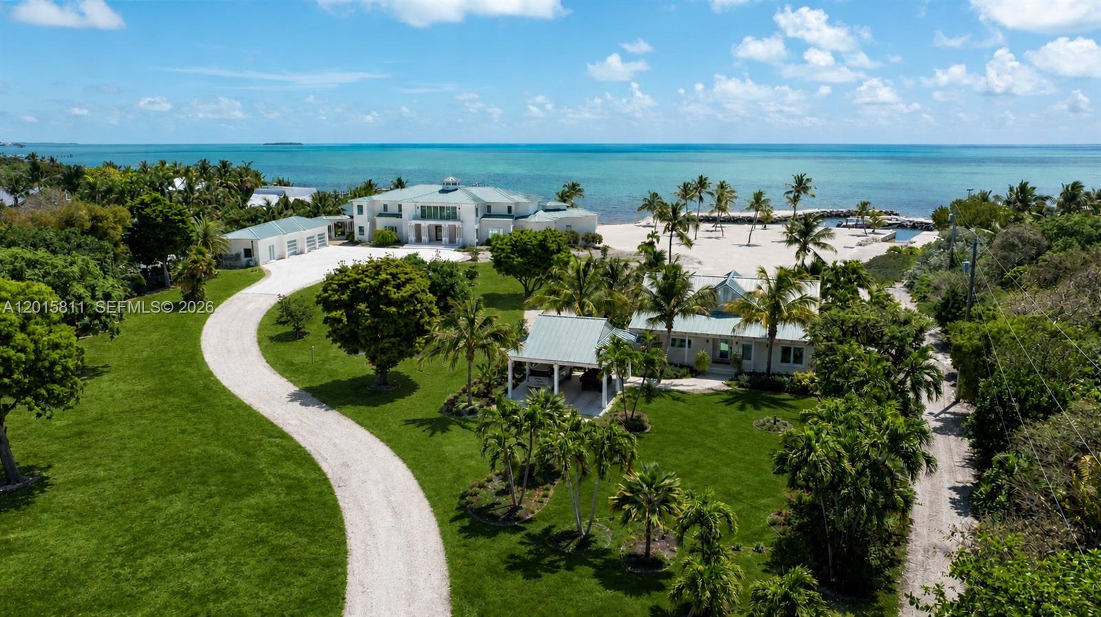 A rare dual-parcel offering on prestigious Millionaire’s Row in Tavernier, 88835 and 88845 Old Highway present an extraordinary opportunity to own one of the Upper Keys’ most expansive and versatile oceanfront compounds. Spanning multiple acres with 480 feet of waterfrontage, the property combines exceptional privacy, premier boating access, and remarkable future development potential. At 88845 Old Highway, a newly constructed 8,200 SF modern estate showcases 5 bedrooms, 6 full baths, 2 half baths, designer finishes, smart-home technology, a resort-style 120-foot pool, and a protected basin with dockage, boat lift, and deep-water access. Complementing the main estate, the adjacent parcel at 88835 Old Highway encompasses over 3 additional acres and introduces a rare layer of flexibility and long-term value. The property includes a renovated 3-bedroom residence completed in 2022, a transferable TDR allowing for the future construction of a substantially larger primary residence, an additional buildable lot, and a lush natural hammock buffer that enhances privacy and exclusivity. Together, this exceptional compound delivers an unmatched blend of luxury living, investment potential, and future flexibility in one of the Florida Keys’ most coveted waterfront settings.