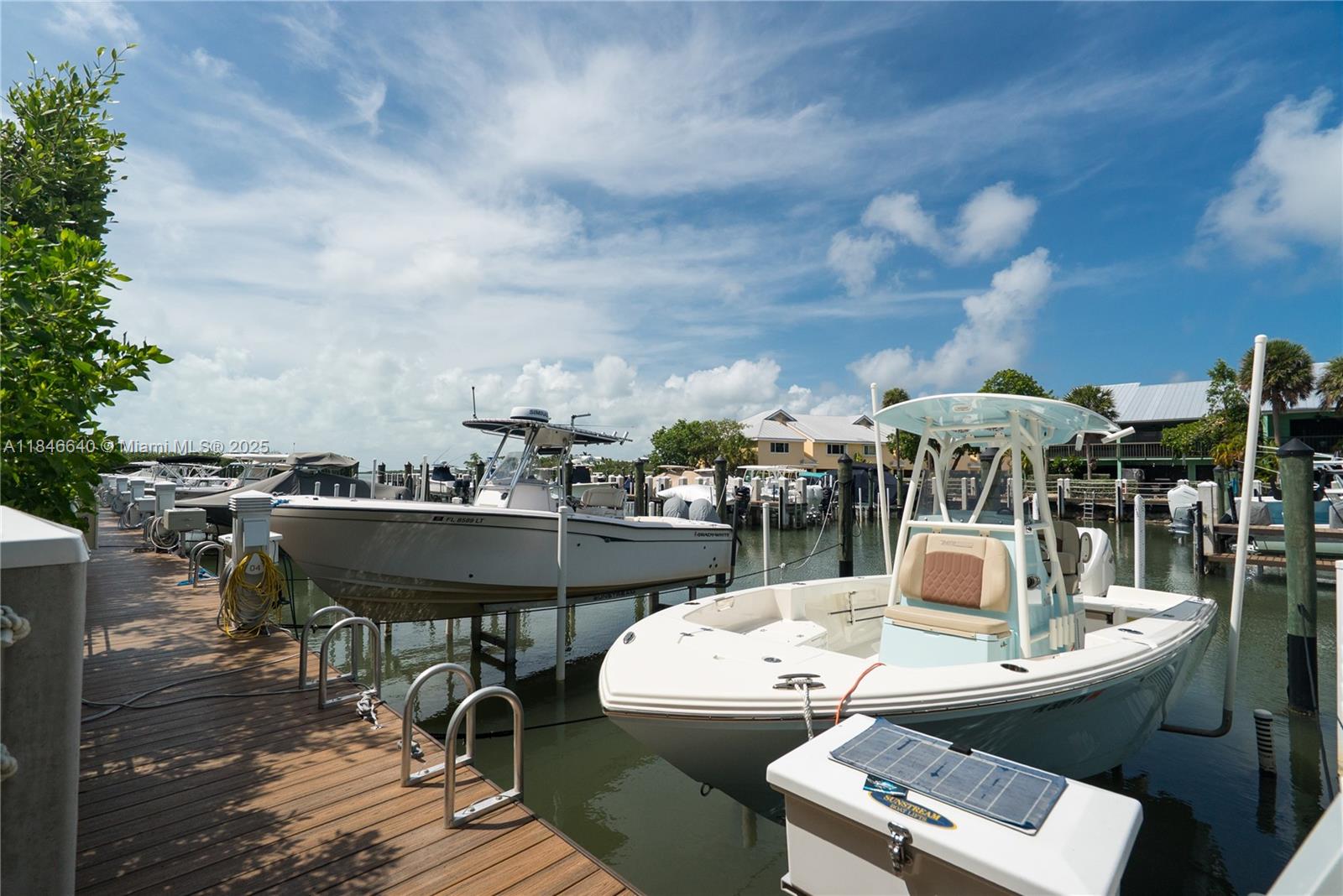 Beautiful Townhome with Deeded Boat Slip in The Landings of Largo! Welcome to the waterfront lifestyle you've been dreaming of—complete with Deeded Boat Slip #3 and an 8,000 lb boat lift just steps from the community boat ramp. This spacious 3-bedroom, 2-bath upstairs townhome also features an enclosed lower-level recreation area approximately 1000 sf., with a full bath, ideal for guests, hobbies, or flexible living. Inside, you'll find vaulted ceilings, beautiful wood-look tile flooring throughout, custom wood cabinetry, and impact windows and doors (excluding the rear balcony) The front balconies have been enclosed, creating additional air-conditioned living space, while the L-shaped screened balcony offers a relaxing view of the main pool.