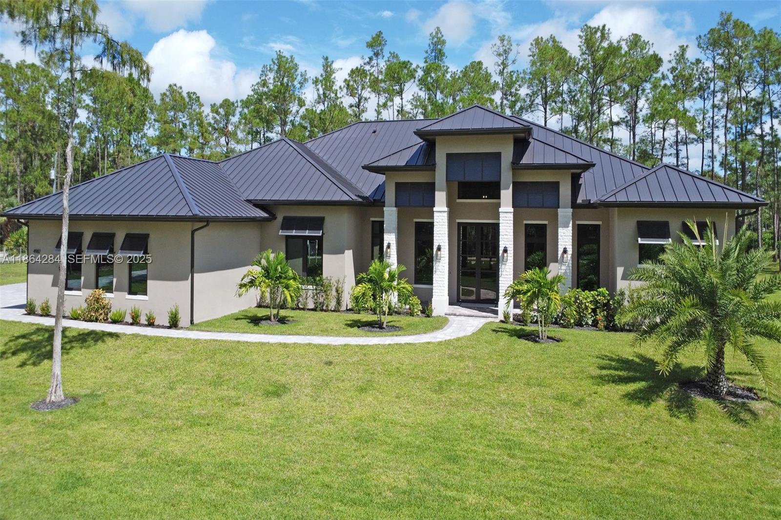 Discover your private retreat in Logan Woods. This new estate sits on nearly 3 acres, offering space, privacy, and a refined Naples lifestyle minutes from beaches, dining, and shopping. The open layout features wood-look porcelain tile, soaring ceilings, and a chef’s kitchen with custom cabinetry, premium appliances, gas stove, walk-in pantry, and spacious island with brass accents. A wet bar with wine fridge adds convenience. The primary suite includes a spa-style bath with soaking tub, dual vanities, double shower, and outdoor shower, while all bedrooms have walk-in closets and en-suites. Outdoors, enjoy a screened living area with summer kitchen, fireplace, and sparkling pool.