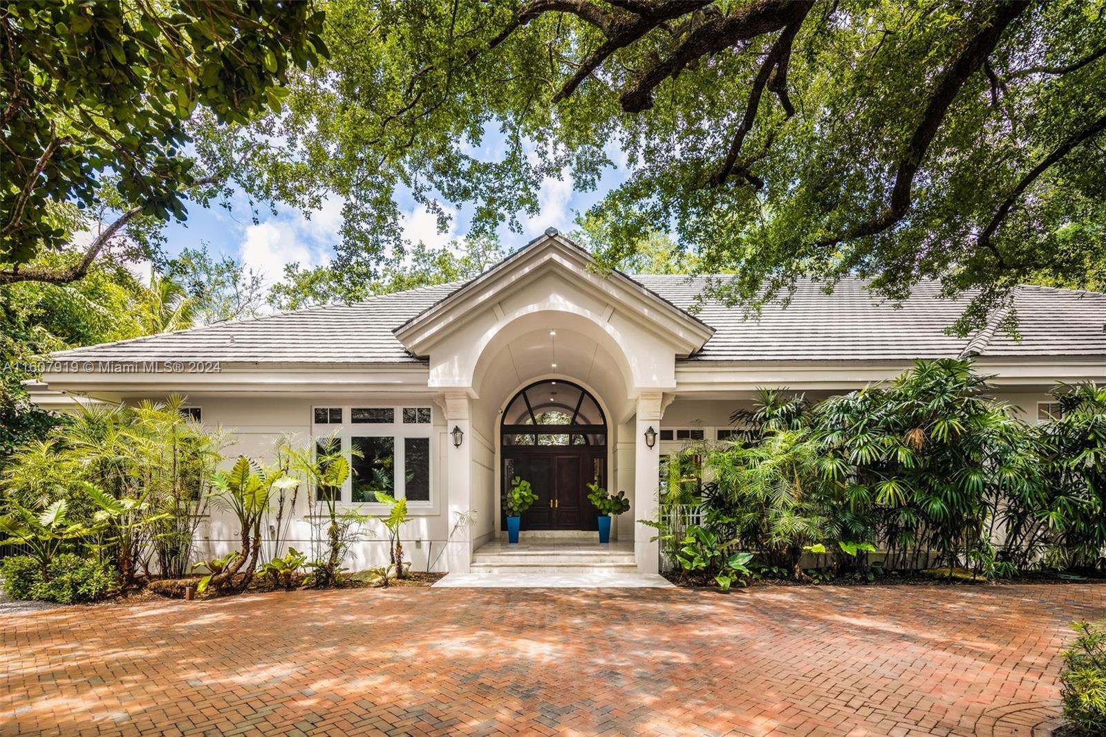 Exceptional Custom One-Story Tropical Sanctuary in Pinecrest on an acre! This 6 BD / 5.5 BA, 7,345 Total SF Estate seamlessly integrates expansive interiors w/ an outdoor oasis. Double mahogany doors open to voluminous ceilings & MQ transom windows providing views of lush landscaping from every room. Gourmet kitchen boasts a breakfast nook w/ views of the resort style pool & backyard, large island, & 146-bottle wine fridge that leads to a large vaulted-ceiling family room w/ wet bar. Entertain under the screened patio w/ fully equipped summer kitchen. Separate guest quarters w/ full bath. Primary suite w/ 2 walk-in closets, seating area, lavish bath, & screened porch. 4 addt'l bdrms w/ high ceilings & walk-in closets (2 en-suite). 3.5 Car Gar, 40 kw Generator, Pinecrest Elem. School Zone.