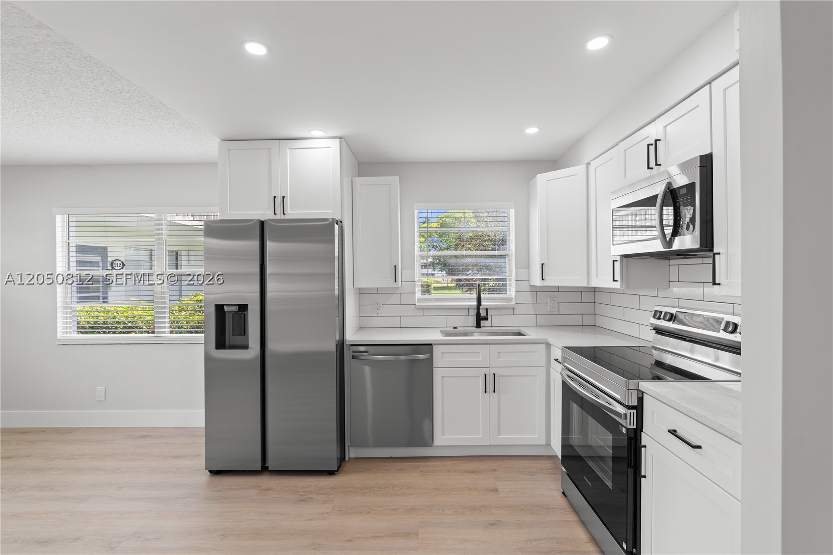 Welcome to this beautifully updated 1-bedroom, 1.5-bath first-floor condo in the highly sought-after Oakridge section of Century Village Deerfield Beach. This move-in ready home features a bright, open-concept layout with a renovated kitchen showcasing updated cabinetry, countertops, backsplash, and new stainless steel appliances. Both bathrooms have been tastefully remodeled. Recent upgrades include a new tankless water heater, central A/C, new electrical panel, updated lighting, modern fixtures, and a spacious enclosed patio. Enjoy the exceptional Century Village lifestyle with resort-style amenities including a clubhouse, pools, fitness center, tennis and pickleball courts, theater, restaurant, social activities, and courtesy bus transportation. Conveniently located just minutes from shopping, dining, and major highways.