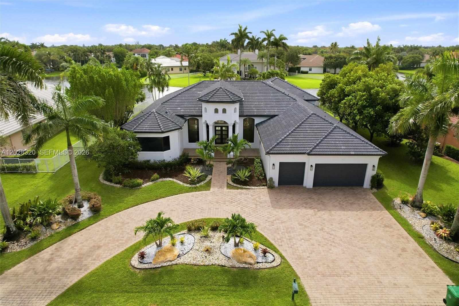 Enjoy refined waterfront living in this fully remodeled single-story home in the prestigious man-gated community of Stonebrook Estates. The elegant triple-split layout features five spacious bedrooms with ensuite baths, 5.5 bathrooms, and a private office. Highlights include volume ceilings and an expansive primary suite with large dual walk-in closets. Recent upgrades include new impact windows, a beautifully refinished diamond-brite pool, updated lighting, custom closets, new bedroom flooring, a transformed gourmet kitchen, refreshed laundry room, and fresh interior and exterior paint. Lush landscaping and epoxy-finished garage floors make this home truly move-in ready. Stonebrook Estates offers resort-style amenities such as a well-appointed clubhouse, fitness center, lighted tennis courts, basketball court, and a community playground, along with 24-hour man-gated security, nightly roaming patrols, scenic lakes, and beautifully landscaped grounds.