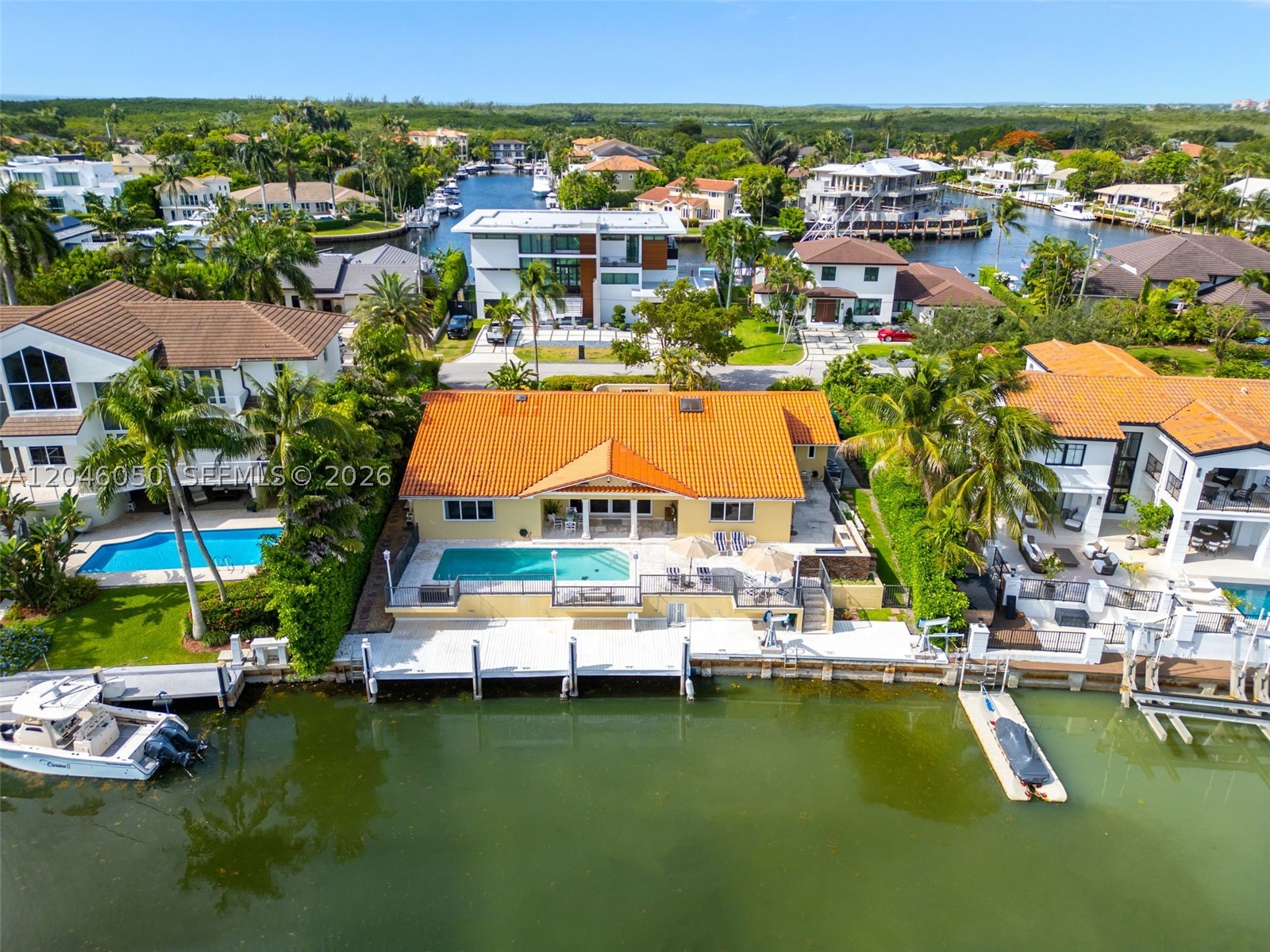 Rarely does a property combine 100 FEET OF WATERFRONT, direct access to Biscayne Bay and the ocean with no bridges, dockage for a boat up to 90 feet, and the security of one of CORAL GABLES' most coveted gated communities. Situated on a 12,000 SF lot with lush landscaping in the prestigious GABLES BY THE SEA, this exceptional waterfront residence offers the lifestyle discerning boaters and families seek. Designed for effortless indoor-outdoor living, the home features expansive waterfront entertaining areas, including a resort-style pool, private dock with electric boat lift, davit, and a fully equipped 48-inch outdoor summer kitchen with grill and sink. Offering 4 bedrooms and 4 bathrooms, a two-car garage, a circular driveway, and a generator. The chef's kitchen showcases professional Viking and Bosch appliances, double-drawer beverage refrigeration, a wine cooler, custom cabinetry, and premium finishes throughout. Three new AC systems were installed in 2025. Gables by the Sea is highly sought after for its gated security, family-friendly atmosphere, and exceptional boating lifestyle. Families will appreciate the proximity to top private schools, including Gulliver Preparatory School, only 4 minutes away, as well as Ransom Everglades and Carrollton School of the Sacred Heart. For buyers seeking an exceptional waterfront lifestyle in one of Coral Gables' most exclusive communities, this is a rare opportunity not to be missed.
