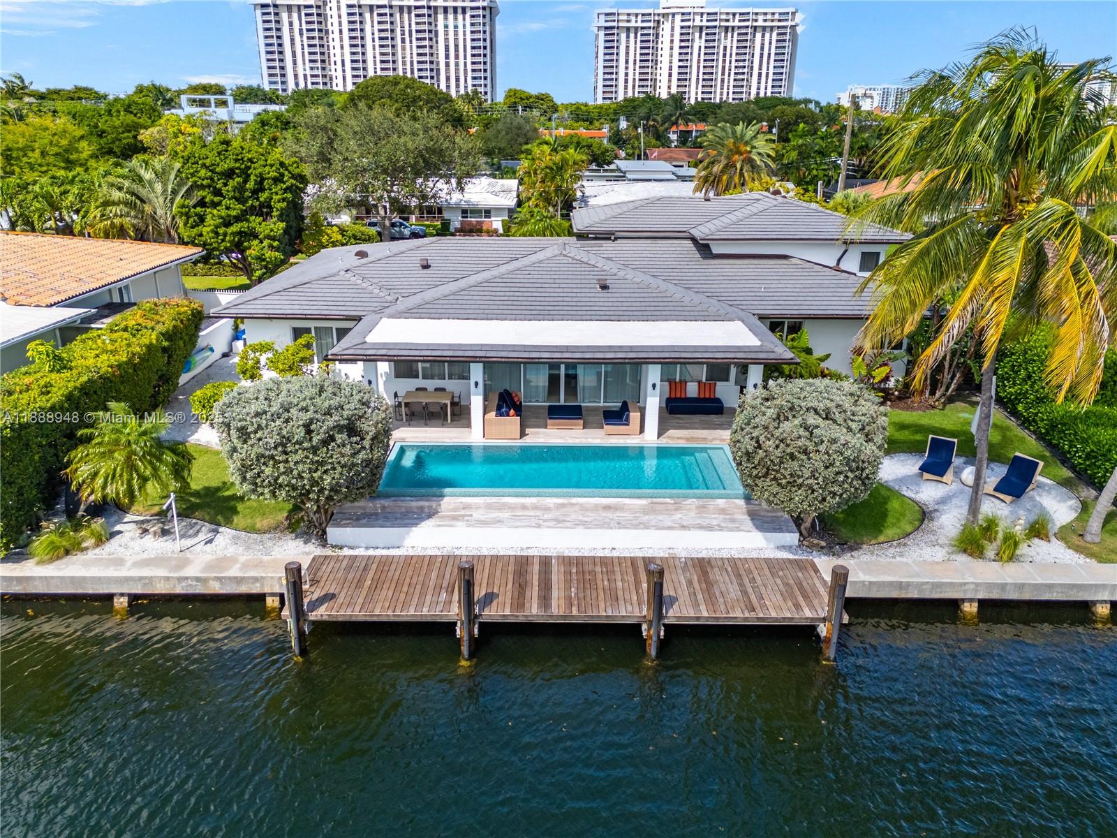 Miami Shores luxury waterfront home with 100-ft of protected waters, 38-ft Ipe dock, and new seawall - moments from the open bay, ideal for boaters! Fully renovated and upgraded with modern features, this 4-bed 4.5-bath home has expansive open living spaces, vaulted ceilings, impact windows and doors, Scavolini kitchen, alarm and music system, natural gas, and elegant entry foyer with floating staircase. Upstairs, large primary suite with a spa-like bath, oversized walk-in shower, private water closet with bidet, and ample storage. The large backyard with an infinity-edge pool and spacious covered patio are perfect for enjoying life on the water. Attached 2-car garage completes this property.   Exclusive location in this sought-after Miami Shores community.