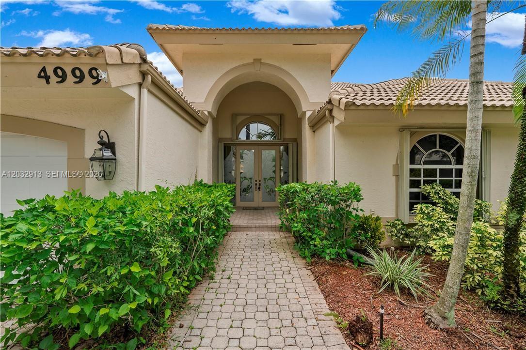 Beautifully maintained waterfront pool home located in one of Coral Springs’ most sought-after gated communities with 24-hour security and a family-friendly atmosphere. This spacious residence features a desirable split-bedroom floor plan with soaring ceilings throughout, including the luxurious primary suite. The primary bedroom offers direct access to the screened pool area, stunning lake views, a private A/C unit for personalized comfort, and custom his-and-her walk-in closets with newly installed shelving.

Designed for comfort and efficiency, the home features three separate A/C systems, allowing independent temperature control throughout. Recent upgrades include a new roof, hurricane-impact windows and doors, solar panels that help reduce electric costs, and a state-of-the-art water treatment system.

Enjoy South Florida living at its finest from the screened pool and patio overlooking tranquil water views. The backyard is enhanced by mature mango and star fruit trees that produce generously throughout the season, creating a private tropical retreat.

Conveniently located near top-rated schools, shopping, dining, parks, and major highways, this exceptional home offers the perfect blend of comfort, efficiency, security, and resort-style waterfront living.