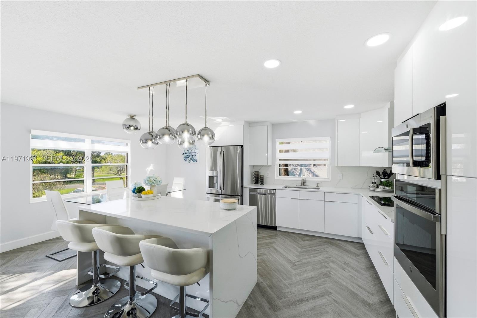 Beautifully maintained and thoughtfully redesigned condo in Century Village. This exceptional unit blends contemporary elegance with everyday comfort. Move-in ready and ideal for buyers seeking style, convenience, and an active lifestyle. Upon entry, you are welcomed by a bright, open layout filled with natural light, the chef-inspired kitchen is a true focal point, featuring a striking quartz waterfall island, stainless-steel appliances, and sleek European-style cabinetry. One bedroom offers a private balcony with relaxing pool views, while the spacious primary suite includes a walk-in closet and a beautifully updated bathroom designed with modern finishes. The home has been fully remodeled with attention to detail and includes a New tankless water heater, A/C (2023), an on-site storage unit providing valuable additional space. Enhancing the lifestyle appeal, the unit is ideally positioned across from a brand-new walking park, perfect for reading, relaxing, or enjoying daily exercise. From the patio area, residents can appreciate scenic views of the pool and nearby tennis courts, convenient access to the community health club gym featuring fitness classes, an additional exercise pool, and an extensive array of amenities in the Million dollar Club House. This is a rare opportunity to own a turnkey, designer-inspired residence in a prime location with resort-style living and unmatched convenience — schedule your private showing today!