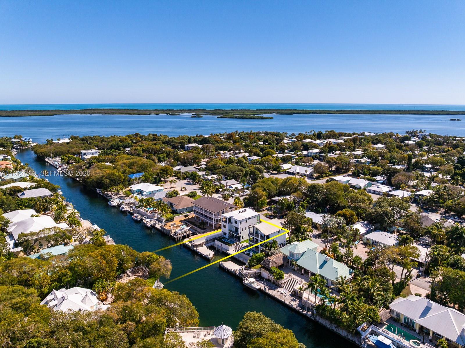 Claim your position on one of Key Largo’s most strategic stretches of water. This masterful new residence on Adams Cut delivers direct access to both ocean and bay. Two docks for serious boating, with a lift in place and room for a second. Whether you’re running offshore at sunrise or cruising into the bay at golden hour, departure is effortless & return is even sweeter. The concrete structure exudes modern beauty w/low-maintenance ownership. Floor to ceiling impact windows frame 180 degrees around the floating concrete staircase that reads like an art piece. Entertaining is easy w/Wolf gas range, Subzero refrigerator, & beverage fridges. A private elevator services 3 stories. Second floor has a primary suite w/balcony overlooking the water, plus 2 more bedrooms. The top floor boasts a 2nd primary suite, and a full entertaining wing with/balcony & ample built-in bar ready to host game nights after a full day on the water. Outdoor paradise continues w/low-key turf, summer kitchen, and heated/chilled pool & spa. One car garage, Sonos system, & automated blinds using Control 4 & Lutron, are just a few features bolstering this home's lock-and-leave luxury allure. Key Largo is less than an hour from Miami, but worlds away in relaxation & mindset–the pinnacle of tropical living. This waterfront residence is built for those who understand the rhythm of the Keys — early departures, unhurried afternoons, & evenings defined by horizon lines rather than deadlines.  A Very Special Home