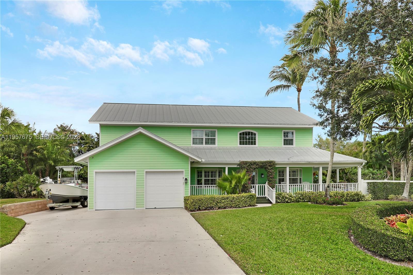 This Charming 2 story Key West Style home and grounds located in Hobe Sound traverse 2 Lots and offer the utmost privacy and tranquility surrounded by tropical flora and fauna. From the moment you and your guests arrive to this special property the weight of the world quickly disappears as you walk up the steps onto a Wrap Around Porch of days gone by when people used gather and relax to welcome the day with a cup of coffee or enjoy a sunset and conclude the day with a cocktail with family and friends. The story unfolds as you walk through the French Doors into the 2 story foyer with a double back staircase and crisp white banisters and railing. The main level features a spacious open floorplan with Dinning/Living/Kitchen, full size laundry room, 1/2 Bath, a Full bath with a Den/5th Bedroom and a cozy built-in Bar Room. The second floor boasts a Primary Suite of Epic Proportions complete with a new sumptuous Primary bath and huge walk-in Closet. 3 More Guest Bedrooms and a Full Bath are sure to please one and all. The second floor has a gorgeous veranda that spans the enter length of the main house and is accessible from the Primary and 1 of the bedrooms. The exterior grounds are to be seen to appreciate and include a large free from pool and a beautiful outdoor kitchen just to name a few of the features for your enjoyment. Full 2 Car Garage is attached and the driveway is big enough to accommodate 8-10 vehicles off of the street. This is a MUST SEE Property to appreciate !!