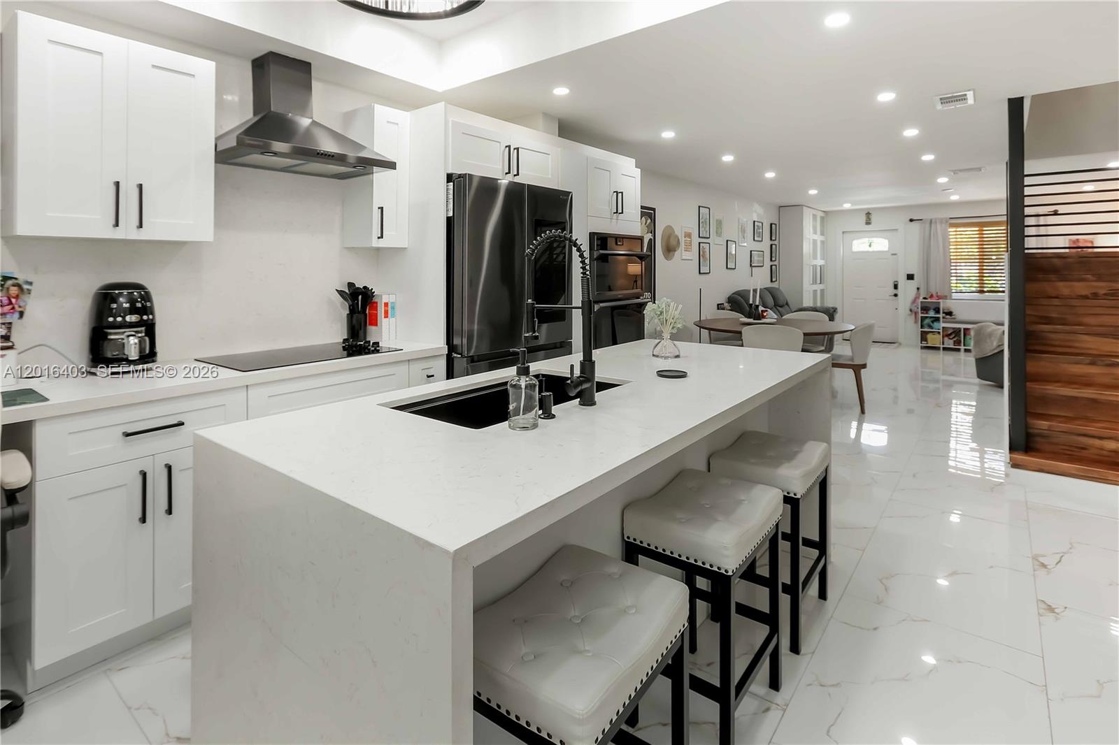 Step into modern luxury with this beautifully updated 2 bed 2.5 bath residence! From the moment you enter, you’ll notice the sleek contemporary finishes, spacious layout, and high-end upgrades throughout. The stunning chef’s kitchen serves as the heart of the home, featuring white shaker cabinetry, a waterfall quartz island with an oversized black stainless steel sink, touchless faucet, built-in pantry, and premium black stainless steel Samsung appliances including a built-in oven and microwave duo.

The open-concept living spaces are enhanced by large continuous porcelain tile flooring throughout the first floor, recessed lighting, and a custom-designed three-tier entryway closet offering exceptional storage. Hurricane impact windows and doors with remote-controlled privacy glass patio door.

Upstairs, wood flooring flows throughout, highlighted by a sleek black staircase railing. The spacious primary suite offers a large walk-in closet and a spa-inspired bathroom featuring elegant black finishes and a state-of-the-art smart toilet with heated seat, bidet functions, and auto flush technology. The secondary bedroom is equally impressive with its own updated ensuite bathroom and sizable closet.

Enjoy indoor-outdoor living year-round with the enclosed lanai and your own tropical private pool oasis. Addt'l upgrades include a high-end LG black SS stackable washer and dryer, security camera electrical hookups, and the 2026 roof replacement assessment already paid in full.