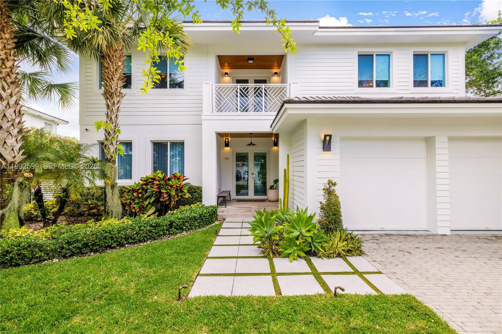 Nestled within the private, gated enclave of sought-after SOMI ESTATES—an exclusive community of just 9 homes—this stunning Coastal Contemporary-style residence blends luxury, comfort, and sophistication. Situated on a 10,050 SF lot, this 5-bedroom, 4 full bath, 2 half bath home is designed for elegant living and effortless entertaining. A welcoming foyer opens to a breathtaking pool with water feature and tanning ledge. Light-filled interiors showcase soaring ceilings, 24x24 white marble floors, and an open layout. Enjoy a cozy formal living room and an expansive great room featuring a chef’s kitchen with quartz countertops, stainless steel GE Monogram appliances, a dining area with modern chandelier, and family room with French doors to a covered terrace surrounded by lush tropical landscaping. A first-floor bedroom and full bath add convenience. Upstairs, a custom angled cable staircase leads to a loft-style sitting area and four bedrooms with custom closets and built-ins. The primary suite offers a private balcony, boutique-style walk-in closet, space for office or vanity. The spa-like bath features dual sinks, separate shower, and soaking tub. Additional highlights include impact windows and doors, custom treatments, motorized shades, generous kitchen pantry, tall doors, tankless water heater, spray foam insulation, laundry room, and 2-car garage. Prime location near Coral Gables, University of Miami, and major thoroughfares.