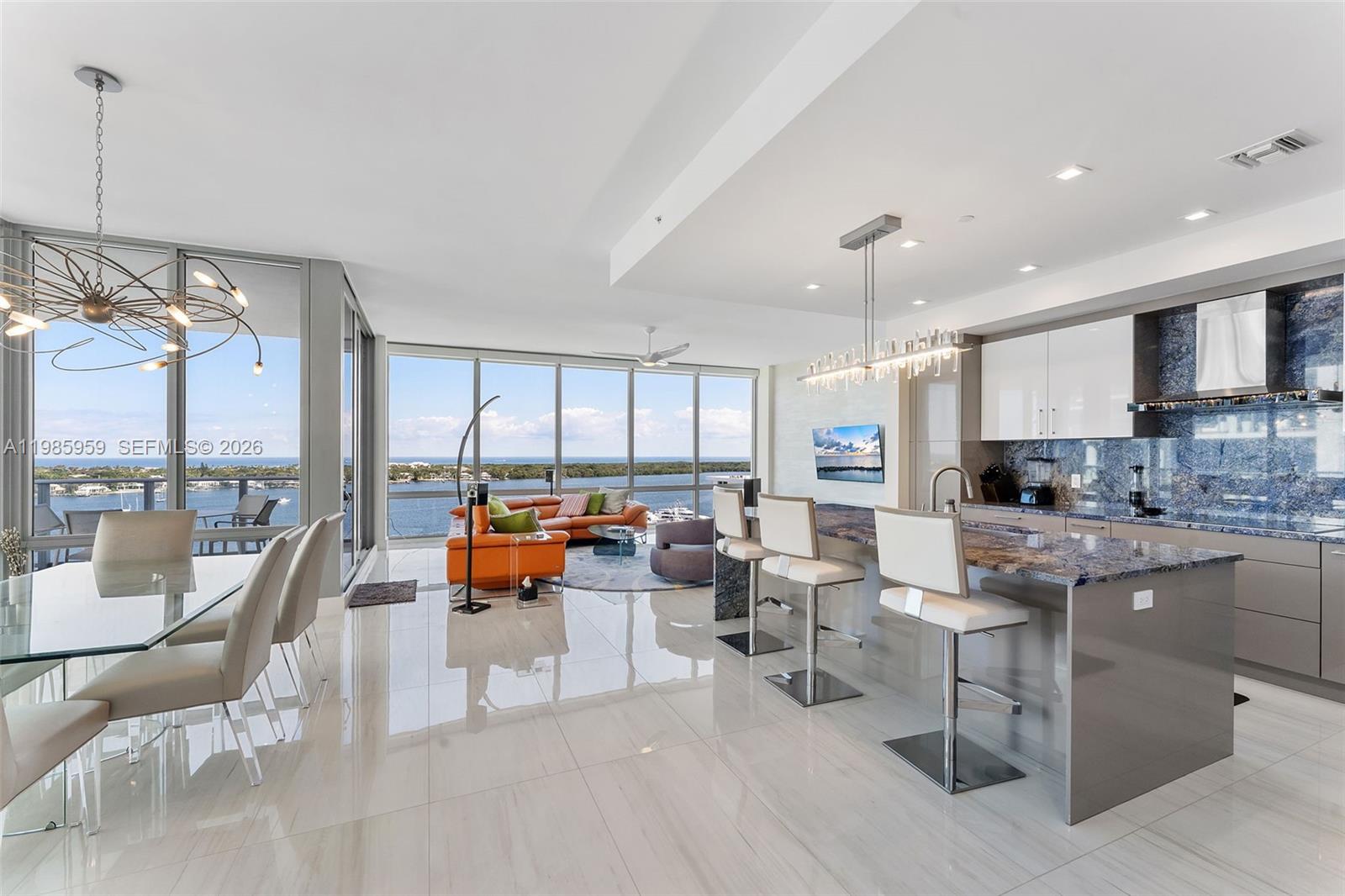 Turn-Key Luxury Designer Waterfront Residence. Experience extraordinary waterfront living in the newest and most coveted tower at the 8-acre Water Club Way in desirable North Palm Beach. This move-in designer-ready 3-bedroom, 3.5-bath residence with office/den offers almost 2,200 square feet of refined interior space and breathtaking panoramic views stretching from the Intracoastal and Atlantic Ocean to the West Palm Beach skyline and luxury yacht marina. Floor-to-ceiling glass fills the home with natural light, while the expansive balcony creates a seamless indoor-outdoor lifestyle—perfect for sunrise meditation and sunset entertaining. 
The chef’s kitchen is beautifully appointed with Jenn-Air appliances, an oversized island, and wine refrigerator, ideal for hosting. Porcelain flooring (24” x 48”) runs throughout, complementing spa-inspired bathrooms with rain showers, a Roman soaking tub, and top of the line designer finishings.
The master bedroom suite is elegantly furnished and features a spacious walk-in closet.