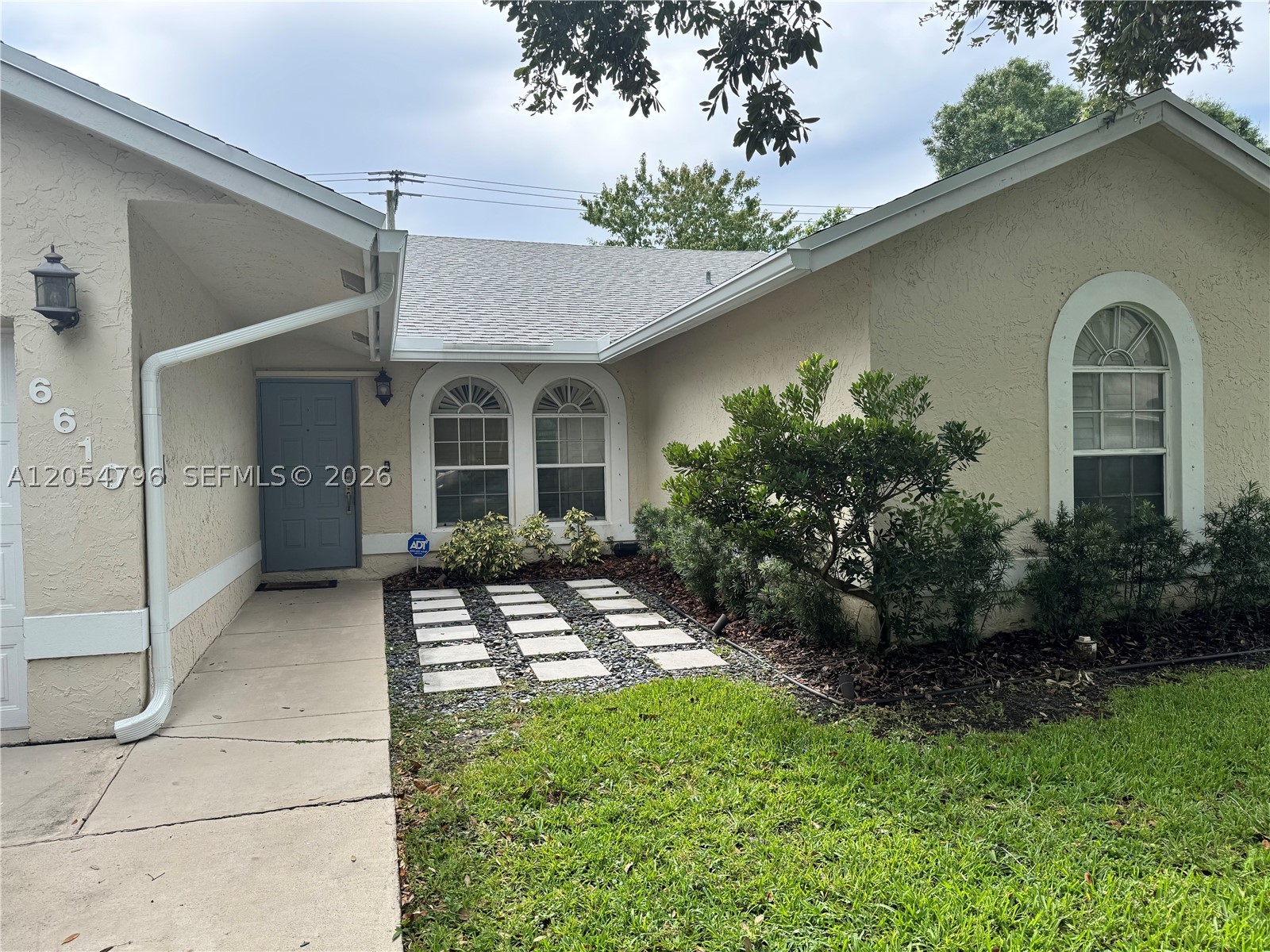 Rare opportunity to own the sought-after Beechwood model in the highly desirable Parkwood VI community. This beautifully maintained 3-bedroom, 2-bath home sits on a private waterfront lot and offers a spacious open floor plan with soaring vaulted ceilings, tile flooring throughout the main living areas, and wood flooring in the bedrooms. The fully remodeled kitchen features granite countertops, stainless steel appliances, and opens seamlessly to the bright living and dining areas. The split-bedroom layout provides added privacy, while the spacious primary suite includes a walk-in closet. Both bathrooms have been tastefully remodeled, and the interior has been freshly painted. Recent updates include a new roof (less than one year old), A/C system (less than three years old), Wi-Fi-enabled sprinkler system, automated smart blinds, hurricane shutters, and a digital water heater. Step outside to a screened patio with a sparkling pool and waterfall overlooking tranquil water views—perfect for relaxing or entertaining. Conveniently located in the heart of Coconut Creek with a low HOA