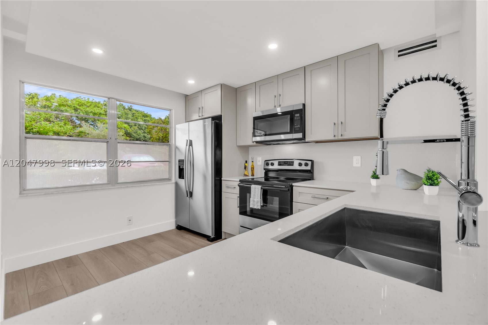 Completely remodeled 2-bedroom, 2-bathroom condo with beautiful lake views! This light-filled apartment features an open-concept floor plan, a stunning kitchen with stainless steel appliances, and modern finishes throughout. Enjoy smooth ceilings with no popcorn, recessed lighting, and contemporary flooring. Both bathrooms have been fully renovated with brand-new walk-in showers, while the spacious primary suite offers a double-sink vanity for added convenience. Relax on your private patio overlooking the lake and enjoy the perfect combination of style, comfort, and functionality. Move-in ready! Located in a desirable 55+ resort-style community offering exceptional amenities, including pools, clubhouse, fitness center, golf, tennis, pickleball, theater, courtesy transportation, and countless social activities. A must-see!