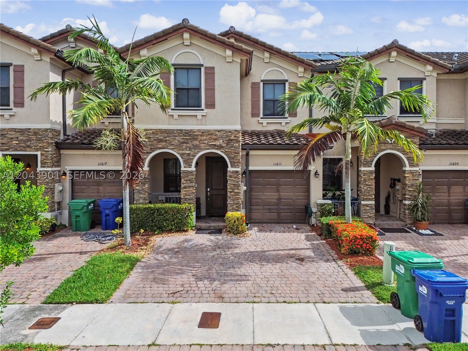 Spectacular LAKEFRONT 2-story townhome in a resort-style gated community in the heart of Homestead — fully upgraded and turn-key! This designer-finished home features an open-concept layout with tile flooring downstairs and wood-look flooring upstairs (NO carpet). The stunning kitchen boasts granite countertops, dark wood cabinetry, stainless steel appliances, and a large island with seating — perfect for entertaining. Elegant glass-railing staircase, modern chandeliers, and a convenient downstairs half bath. The spacious primary suite offers a tray ceiling, custom-built walk-in closet, and a private en-suite with dual vanities and glass-enclosed shower. Generously sized secondary bedrooms with ample closets. Step outside to your showstopping covered patio with direct LAKE VIEWS, fountains, mounted TV, sound system, and cooling fans — the ultimate Florida outdoor living space! SOLAR PANELS for energy savings, full-size washer & dryer, 1-car garage, and paver driveway. Resort amenities include a pool, spa, kiddie pool, clubhouse, basketball courts, playground, and scenic lakes. Near Florida's Turnpike, shopping, dining, and schools. A true gem — schedule your private showing today!