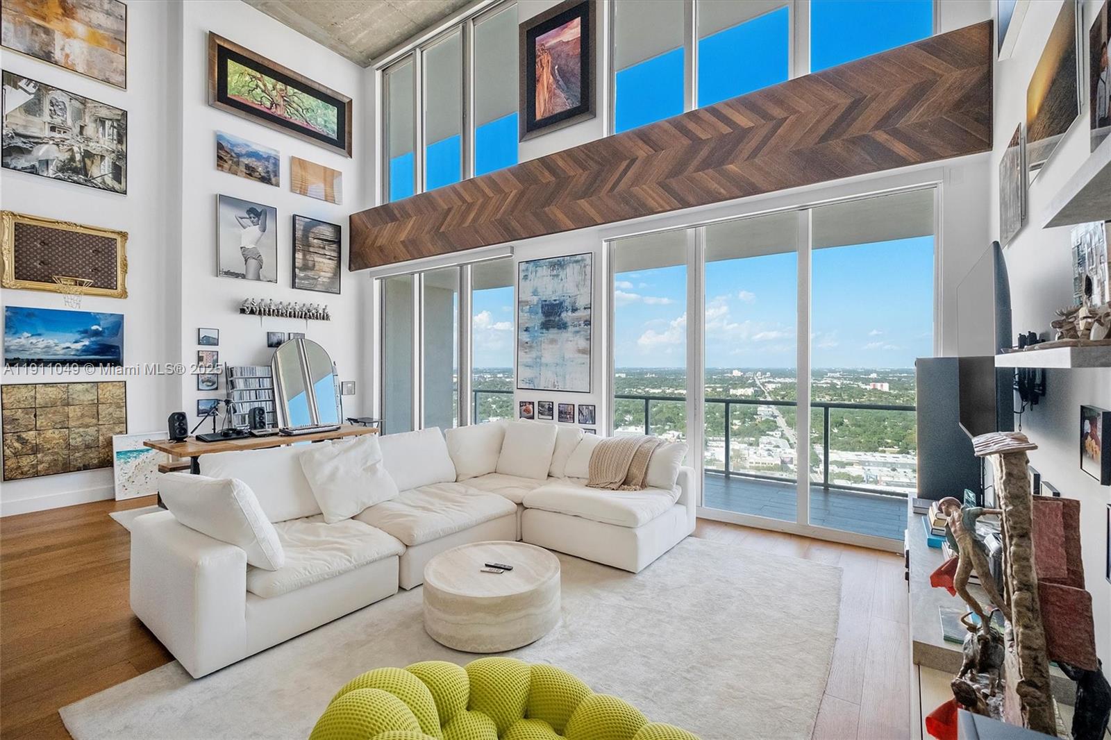 Exquisite two-story penthouse in the heart of Midtown Miami. This one-of-a-kind loft features 2 bedrooms + den, 2.5 bathrooms, and captivating north, west, and east exposures. Multiple terraces, including an expansive wraparound upper terrace, offer panoramic city, bay, and skyline views that capture both sunrise and sunset. Soaring 20-foot floor-to-ceiling windows flood the home with natural light, while double-height walls create a gallery-style backdrop ideal for large-scale art or statement lighting. Thoughtfully renovated with a custom Ornare kitchen, marble countertops, Armadi closets, Mia Cucina bathrooms, and European oak hardwood floors. Offered fully furnished and move-in ready, includes two parking spaces and prime access to the Design District, Wynwood, and Biscayne Bay
