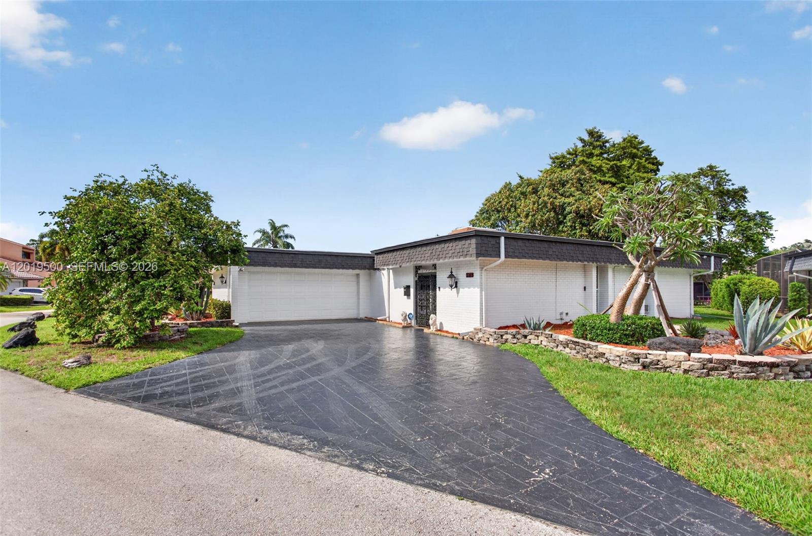 Fantastic home offering over 2,330 sq ft under air, more than 3,400 total sq ft, and situated on an expansive 10,900+ sq ft lot in the desirable Woodlands community of Tamarac, where the major upgrades have already been completed. Recent big-ticket improvements include a new roof (2024), PGT impact glass windows and doors, impact garage door, new General Electric electrical panel, water heater (2021), and AC (2017). This home combines generous living space with exceptional functionality.  Inside, the home features a desirable split floorplan with vaulted ceilings and open living areas designed for comfortable everyday living and entertaining. The primary suite offers two walk-in closets and a spacious ensuite bath complete with a brand-new jacuzzi tub, double vanity, and separate shower. Enjoy year-round use of the huge enclosed patio area, fully protected with impact glass and ideal for additional living or entertaining space. Large yard features three star fruit trees, one large mango tree & pineapple plants. Low HOA fees include community pool access and lawn care. Ideally positioned near shopping, dining, parks, and major commuter routes, this property offers an outstanding combination of space, upgrades & location.