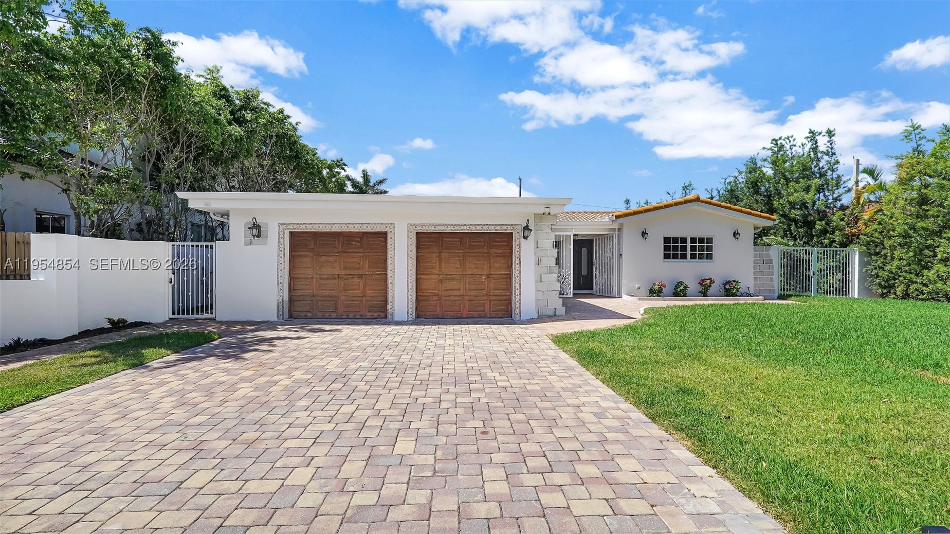 Perfectly positioned in the highly desirable Hollywood Lakes neighborhood, this fully renovated home is just minutes from the beach and steps from North Lake and the newly renovated Hollywood Beach Golf Club. Nestled on a quiet, low-traffic street, it offers a rare combination of tranquility, privacy, and walkable access to some of the area's most sought-after outdoor amenities.

Thoughtfully designed, the split-bedroom layout provides privacy for family and guests, while expansive living spaces create an open, airy feel throughout. Large impact-rated sliding glass doors connect nearly every room to the pool and outdoor living areas, flooding the home with natural light and creating a seamless connection to the surrounding greenery.

The outdoor experience is equally special, featuring a resort-style pool, spacious front and back yards, mature landscaping, and exceptional privacy. Solid concrete perimeter walls and gated access create a secluded retreat ideal for relaxing or entertaining. Inside, the home is remarkably quiet, with no traffic noise, just the sounds of birds and the breeze.

Completely remodeled in 2022, the home features updated plumbing, electrical, flooring, bathrooms, and finishes throughout. A rare two-car garage provides added convenience, storage, and storm protection.