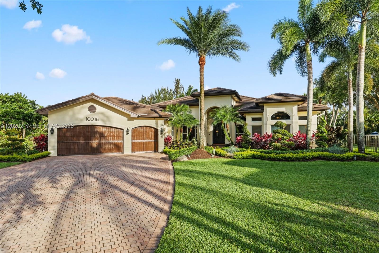 Experience resort-style living in this private 1.3-acre estate featuring 5 bedrooms, 4.5 baths, office, billiards/game room, and a one-of-a-kind custom 6-seat Art Deco theater with Sony electronics and reclining seats. Updated with a new roof and exterior paint, plus full hurricane protection and 9-camera security system. Interior showcases 24x24 marble and wood flooring. Gourmet kitchen features Wolf induction cooktop, Sub-Zero refrigerator, new GE Café oven, granite counters, and walk-in pantry. Oversized laundry includes second refrigerator and wine fridge. Two baths (Jack-and-Jill and cabana) recently remodeled. Surround sound throughout primary suite, den, billiards room, and outdoor areas. Step outside your own private resort featuring an incredible custom saltwater heated pool/spa with grotto, LED Hayward system, 18-ft inner tube slide, three waterfalls, water volleyball, and children's play area. Additional outside amenities include full basketball court, tiki hut with outdoor wet kitchen, outdoor TVs, travertine patio, and lush professional landscaped grounds with lighting system. 3-car garage in guard-gated community with A-rated schools, 15 minutes to Fort Lauderdale-Hollywood International Airport and beaches. A rare opportunity to own a true South Florida estate where every detail has been designed for elevated living, effortless entertaining, and timeless enjoyment.