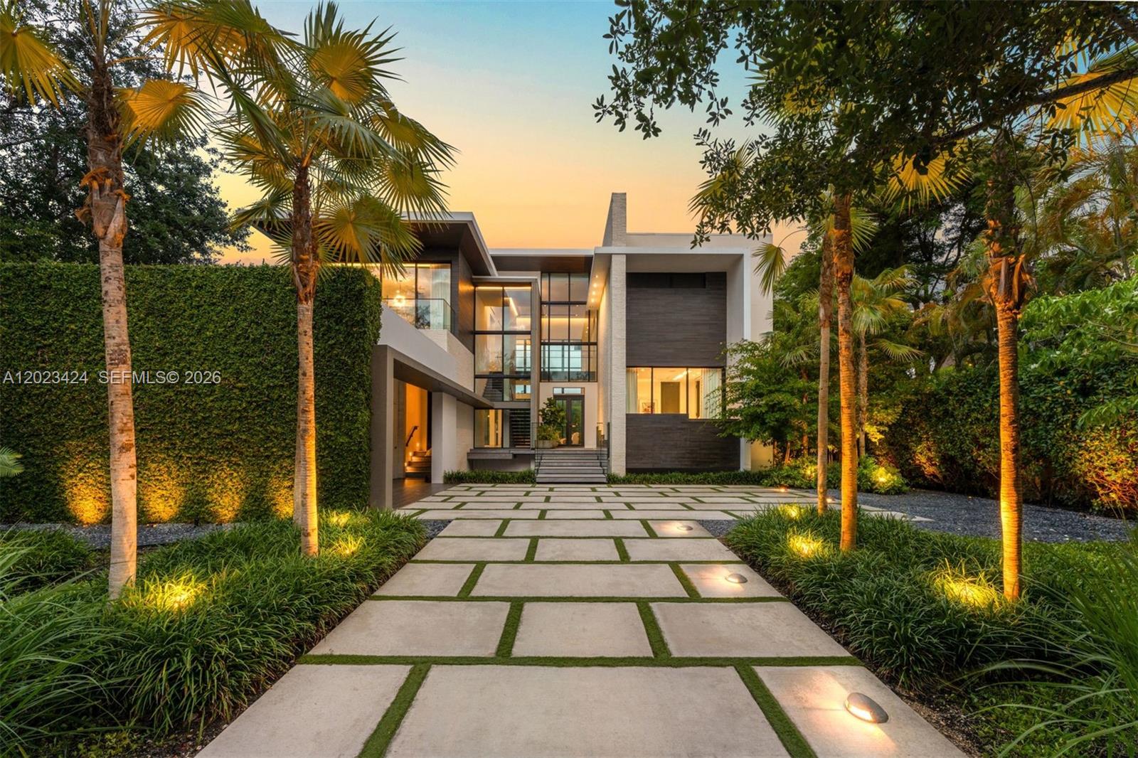 Situated within the exclusive guard-gated Cocoplum community, this striking waterfront contemporary estate by Choeff Levy Architecture offers 7,914 total SF on a 17,730 SF lot with approximately 100 feet of deep-water canal frontage and direct bay access. The 5-bedroom, 6-bath residence is defined by soaring double-height spaces, floor-to-ceiling impact glass, Venetian plaster walls, custom millwork, limestone floors, and seamless indoor-outdoor living. A dramatic floating entry over reflecting pools with sheer descent waterfalls leads to expansive social areas that open completely to the resort-style backyard through retractable glass walls. The chef's kitchen features an oversized porcelain island, custom cabinetry, and premium Gaggenau, Miele, and Sub-Zero appliances. The luxurious primary suite offers a private balcony, spa-inspired bath with freestanding soaking tub, oversized closets, and Sub-Zero refrigerator drawer. Additional highlights include a finished basement with office, gym, lounge, and home theater; elevator; Control4 smart home automation; Sonos audio throughout; whole-house generator with buried propane tank; and reverse osmosis water filtration. Outdoor amenities include a heated black-bottom edgeless pool with integrated spa, FireMagic summer kitchen, covered dining terraces, lush tropical landscaping, and a dock accommodating vessels up to 70 feet. Recent 2024–2025 updates include refreshed landscaping, redesigned pool deck, and updated guest suite.