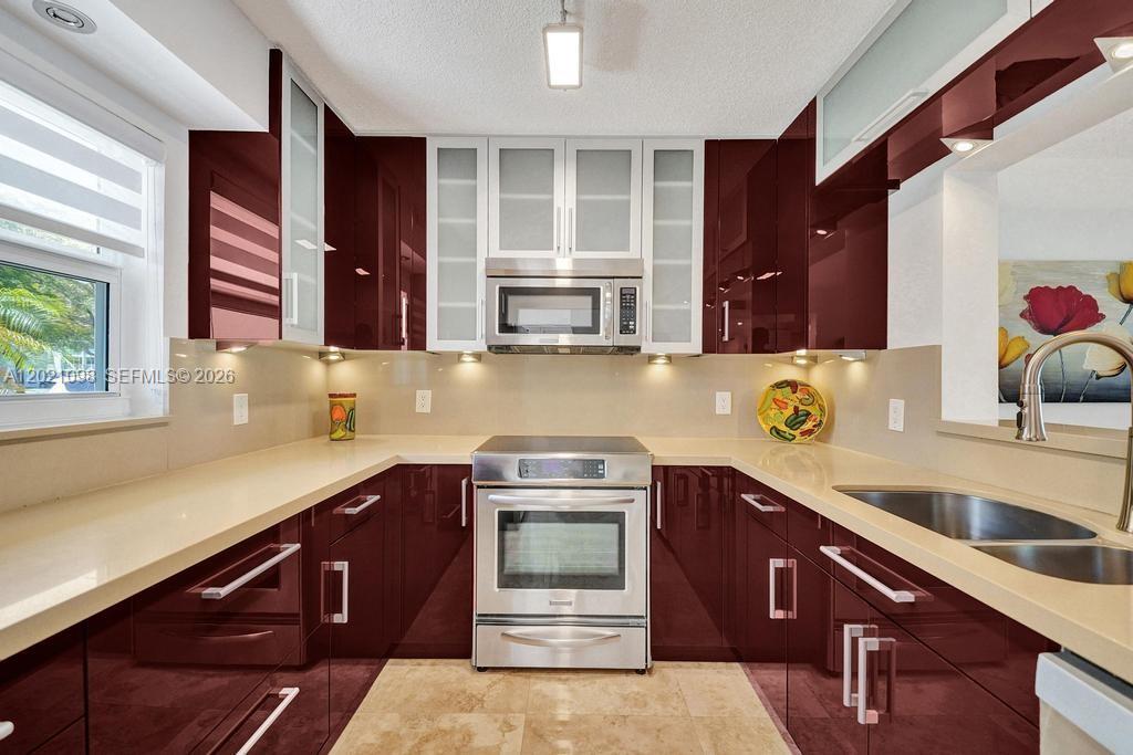 No expense was spared in the complete renovation of this beautifully appointed condo. Top-of-the-line finishes are showcased throughout. Every detail is thoughtfully completed with permits. Washer & dryer in unit! Impact windows and doors provide both style and peace of mind. The open-concept kitchen is designed for effortless everyday living and entertaining. Serene lake views enhance the home's tranquil setting. Desirable ground-floor location adds comfort and convenience. Reserved parking directly in front of the residence offers exceptional ease. This corner unit offers added privacy and natural light. Close to the beach, airport, Port Everglades, shopping, dining, casinos. OK to lease minimum 90 days, 1 time per year, after 1 year of ownership. Elegant marble flooring extends throughout the residence.Located within a sought-after active adult community.Ideally situated near the beach, golf, tennis, and casinos, with convenient access to both Fort Lauderdale and Miami.