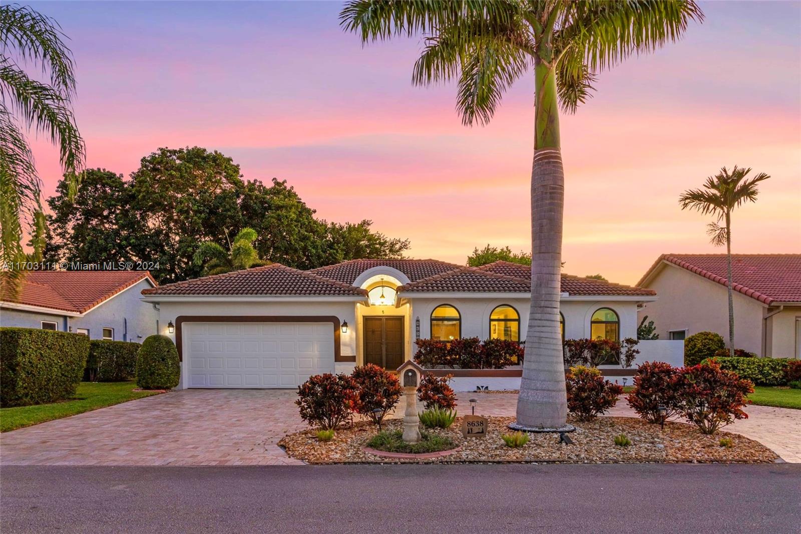 This gorgeous meticulously maintained split-bedroom home is situated on the 4th hole of the Pines Golf Course in Woodmont Country Club Golf Course! Unique tile flooring throughout, updated eat-in kitchen w/ elegant granite countertops,  SS appliances, & ample counter space. Semi-open plan includes vaulted ceilings & custom-built wet bar, perfect for entertaining. The primary bedroom offers sliding doors to an expansive screened patio, a separate dressing area, & spacious closet. The luxurious bathroom includes dual sinks & a step-down shower. A separate laundry room provides additional storage. The expansive screened patio is perfect for relaxing, entertaining, or enjoying stunning golf course or sunset views. Hurricane shutters AND impact windows, & low HOA fees complete this ideal home.