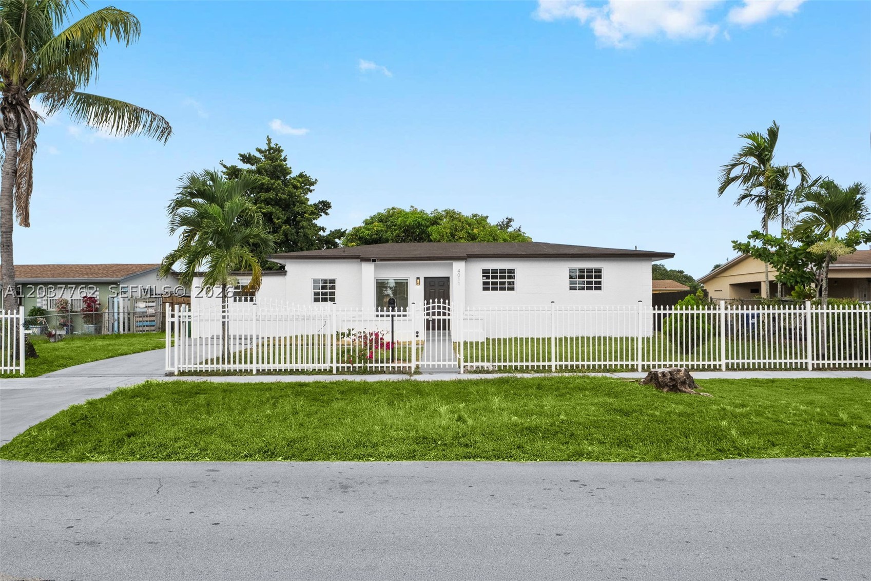 Completely Remodeled 4-Bed Stunner in Miami Gardens — Move-In Ready!
Welcome to 4011 NW 171st St, a beautifully renovated 4-bedroom, 2-bathroom single-family home offering approximately 1,486 sq ft of modern living in the heart of Miami Gardens. Set behind a brand-new white security fence with a gated entry and framed by mature palms, this CBS-built home delivers standout curb appeal and peace of mind.
Step inside to a bright, open-concept layout with sleek large-format porcelain tile throughout, recessed LED lighting, and a spacious great room built for entertaining. The all-new designer kitchen is the centerpiece — white quartz countertops, two-tone shaker cabinetry, a striking fluted waterfall peninsula, full quartz backsplash, and a complete stainless steel appliance package. French doors open to a generous, fully fenced backyard with plenty of room for a pool, garden, or gatherings.