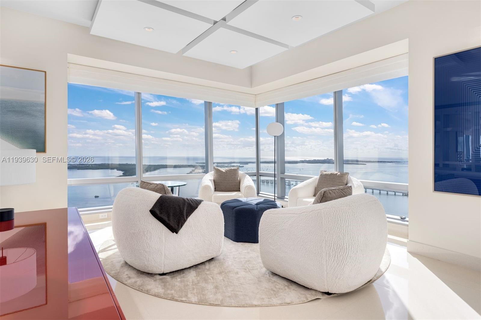 Exclusive corner residence at Millennium Tower Residences offering 3,698 SF of impeccably renovated living space with 3 bedrooms, 4 full baths, and 1 half bath. Glass walls and floor-to-ceiling impact windows frame sweeping views of the Atlantic Ocean, Biscayne Bay, the city skyline, and Port of Miami, filling the home with natural light. A private elevator opens to a refined foyer leading to an open-concept great room with volume ceilings, floating panel details, custom wet bar, and automated shades. The custom marble kitchen features premium appliances and a breakfast area ideal for entertaining. The expansive principal suite includes a sitting area, private balcony, spa-style bath, and oversized walk-in closet. Enjoy Four Seasons 5-star amenities, two parking spaces, storage, and Equinox memberships, all with full-service luxury living.