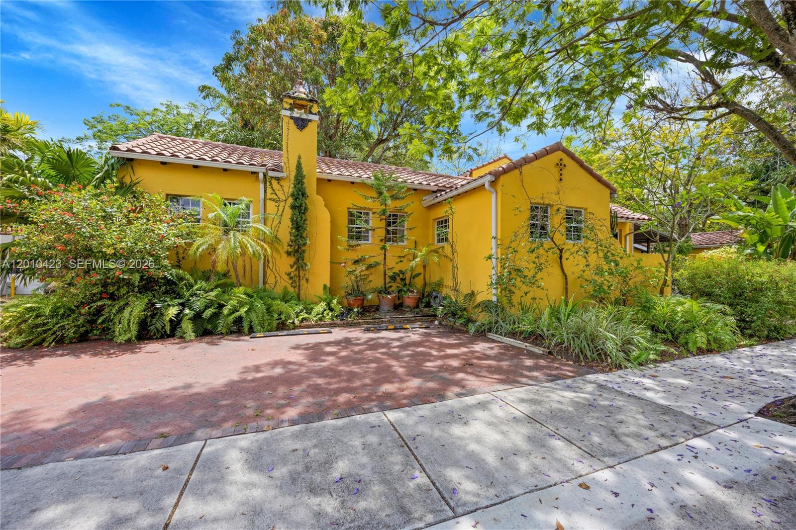 Old Hollywood elegance meets tropical Miami living in Belle Meade! Nestled in one of Miami’s most sought-after gated neighborhoods, this one-of-a-kind 1938 Old Spanish estate sits on a lush double lot surrounded by mature trees, tropical landscaping, and serene garden spaces. The private compound includes a 3-bedroom, 2-bath main residence plus three additional living spaces: a 1-bedroom apartment above the main house and two separate guest cottages, offering a total of 6 bedrooms and 5 bathrooms across multiple living Spaces. Architectural details include dramatic vaulted ceilings in the great room, arched windows, a fireplace, and multiple second-story patios overlooking the verdant grounds. Additional features include impact windows throughout, remodeled kitchen and bathrooms in the main house, updated plumbing and electrical, a newer roof, and a well-water irrigation system. The enchanting outdoor spaces feature lush gardens, a fenced yard, carport, 5 parking spaces and exceptional privacy behind walls and gates. Ideally positioned adjacent to the Belle Meade guard gate for added security and convenience. Located within walking distance to neighborhood shops and restaurants and close proximity to the Design District & beaches, this is a rare opportunity to own a true Miami classic in one of the city’s most beloved neighborhoods.