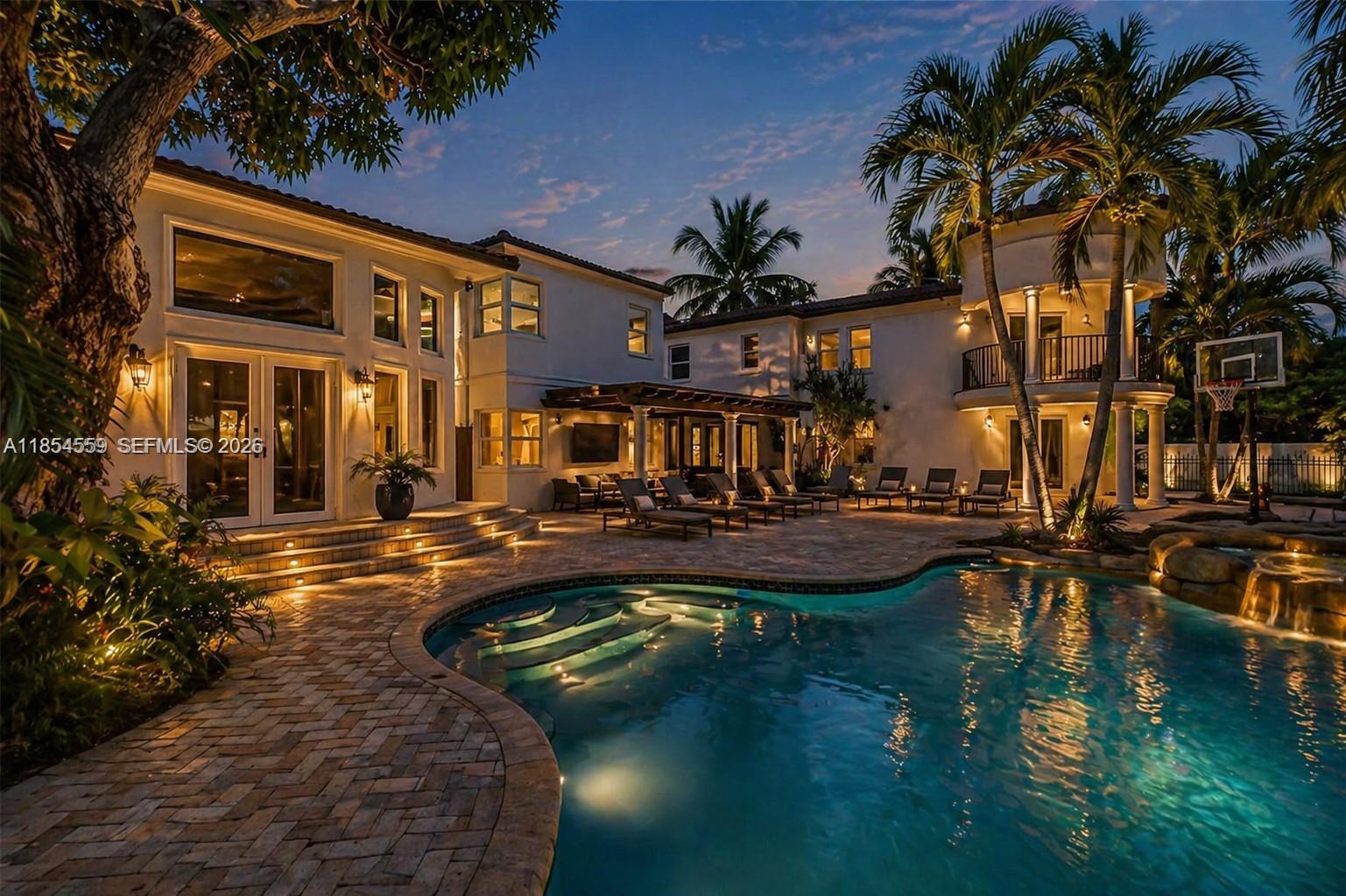 Commanding waterfront estate: 6,200+ sq ft on a sprawling 17,000+ sq ft corner lot with approx 70 ft of canal frontage, private dock, and no fixed bridges to open ocean. A true boater’s dream wrapped in lush tropical grounds and anchored by a resort-style pool designed for entertaining. 7 bedrooms, 5 full + 2 half baths with grand-scale living throughout. Primary suite is a private sanctuary with office, dual walk-ins, two spa-inspired baths, and direct access to pool and water. Striking entry with terrazzo floors, fireplace, and dramatic staircase. 4 bedrooms on the main level, 3 upstairs, plus a private theater. Currently permitted for short-term rentals with a strong performance history, offering rare flexibility for both lifestyle and income. 3D tour and drone footage showcase the full experience.  Images may be virtually staged and/or digitally enhanced (furniture, colors, fixtures, landscaping) for illustrative purposes only.