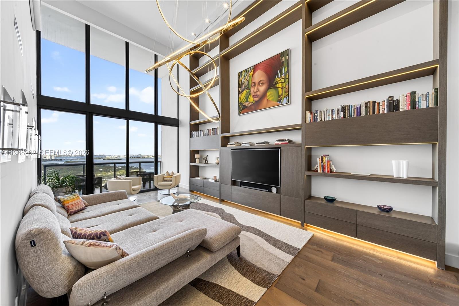 A rare two-story PH in Miami’s highly sought-after Edgewater neighborhood. This expansive 2-bedroom, 2.5-bath residence offers over 2,000 square feet of living space, soaring 22-foot ceilings, abundant natural light, unobstructed Biscayne Bay views and expansive wall space ideal for displaying large-scale artwork or curated collections.  A unique floor plan—unlike any other in the building—provides exceptional scale and privacy with just one shared wall. Open-concept living and dining areas flow to a private balcony, ideal for seamless indoor-outdoor entertaining. Custom built-ins, a sleek bar with a Subzero wine refrigerator and dedicated ice maker, a designer kitchen featuring Miele appliances, Poliform cabinetry, and a marble waterfall island elevate the space. With one bedroom on each level, separate A/C zones, and a primary suite with a walk-in closet and dedicated office overlooking the bay, the layout offers both comfort and flexibility. The second bedroom has its own ensuite bath. Residents enjoy resort-style amenities including a fitness center, sauna, steam room, two pools, business center, children’s play area, and on-site market. Includes 3 parking spaces (2 assigned and 1 valet) and private storage. Ideally located near the Beaches, Midtown, the Design District, and the new Whole Foods.