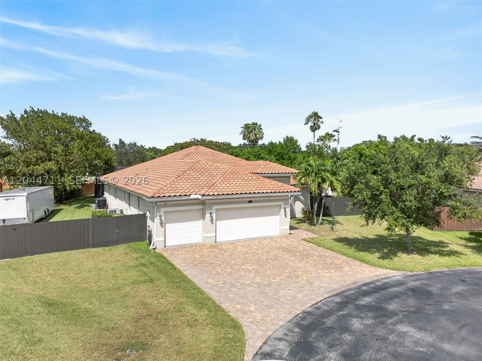 Ranch-like living and easy access to the Keys! Tucked in a quiet cul-de-sac, this 4-bed, 3-bath Homestead retreat sits on an oversized lot built for those who crave space, privacy, and the freedom to live large. The fully fenced grounds, with brand-new fencing with a sliding gate, leave room for your boat, RV, jet skis, and every weekend toy, with even more space in the 3-car garage. Backed by a low, non-intrusive HOA with minimal restrictions. The home is guarded by a high-end security system and shielded against storms with impact doors and windows. Coming in, the foyer gives the home a grand feeling and a thoughtful split floor plan offers privacy and easy flow. The kitchen boasts new stainless-steel appliances, ample cabinetry, and a pantry. With pool views carrying through the kitchen, living room, and the spacious primary suite. Out back, a fully screened private resort: a heated pool, jacuzzi, a covered terrace pre-wired for TV, and dedicated dining and lounge space. Best of all is the calm, the open space, the quiet, and the room to breathe that define this pocket of Homestead, all just minutes from shopping, dining, the Turnpike, and the gateway to the Keys. Enjoy a Saturday grilling by the pool with the family or take a day trip to the Keys. When people think of free Florida living for their family this is what they mean!