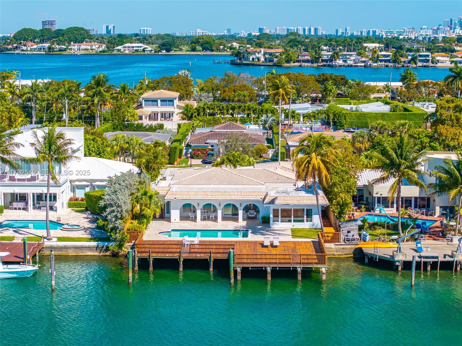 Indulge in waterfront living on Biscayne Bay, this one-story home seamlessly blends Miami Beach luxury with timeless serenity. Nestled within the renowned gated community of Biscayne Point, set on a 12,000 SF lot with 80 FT of Bayfront. Featuring 4 bedrooms, 4 bathrooms, and approx. 4,315 SF of living area, a pool, patio, and private boat dock w/ direct bay access. The expansive approx. 1,811.21 SF dock—one of the island's largest is great for hosting unforgettable gatherings, watching vibrant sunsets and offers panoramic views of the shimmering bay. Inside, the open-concept home is bathed in natural light, with a chef's kitchen—ideal for entertaining. Located minutes from the beach and Bal Harbour Shops. This rare gem captures the essence of Miami Beach living at its finest. Come explore.