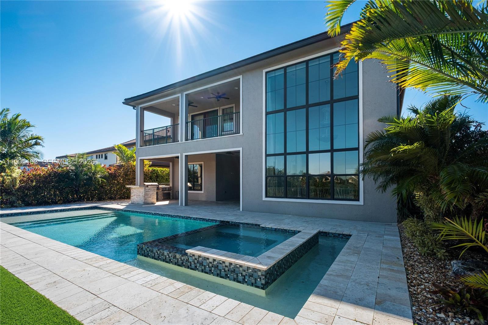 Extraordinary design and attention to detail define this 5-bedroom, 5.5-bath home with an enclosed theater/game room. The expanded Strathmore model features a charming European Cottage stone elevation. Walls of windows fill the home with natural light, showcasing unobstructed waterfront views and a serene nature preserve. Soaring ceilings, a dramatic staircase, and rich hardwood and porcelain flooring enhance the elegant interior. The sophisticated gourmet kitchen offers high-level cabinetry, quartz countertops, double ovens, a gas range, and an oversized island, along with a built-in buffet and wine refrigerator in the dining area. Two en-suite bedrooms are located on the first floor. The primary suite features a private balcony and opens to a travertine patio, lanai, and heated pool and spa. Resort lifestyle living at its finest. Parkland’s “A-rated” schools.
