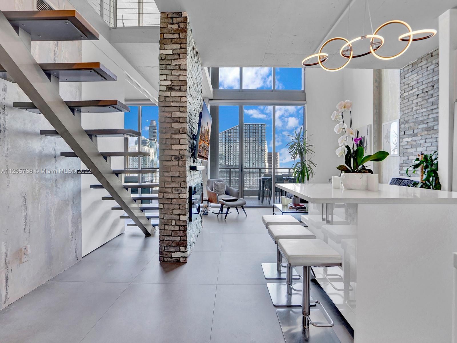 Enjoy breathtaking city and river views as seen through 20 foot floor to ceiling windows from this fully renovated two story, two bedroom penthouse suite. The building’s industrial and modern style is extended into this unique unit via brick veneers and customer walls resembling industrial concrete. The cooks kitchen features ample quartz counter space, stainless steel appliances, and an island that with additional storage and seating space.

The guest area features a custom made retractable partition, queen size murphy bed with lights and storage, and a convertible sofa making this an ideal dual purpose space. The second floor offers a a spacious master bedroom, an office/den, high end LED fixtures, and a spa like master bath.