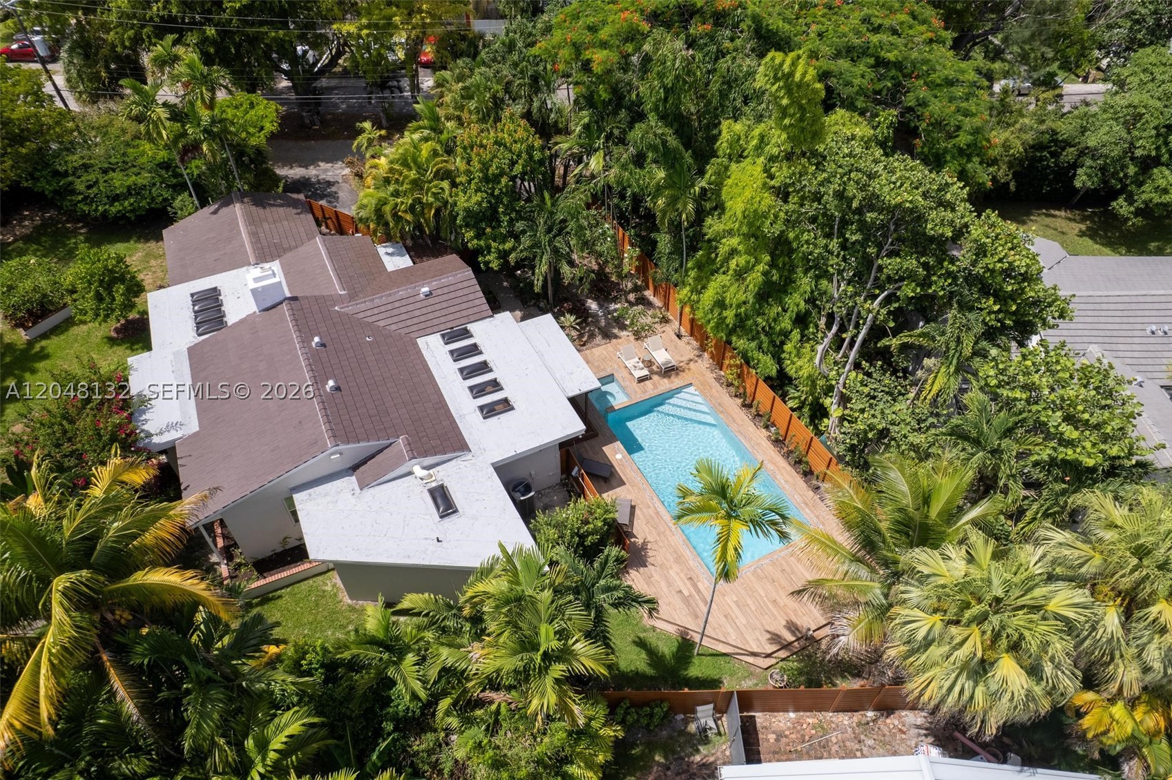 Nestled on an exceptional 15,928 SF corner lot in the heart of Biscayne Park, this beautifully updated 1935 residence blends timeless architectural charm with modern comfort. Offering 3 bedrooms and 3 bathrooms, the home is filled with character, featuring soaring wood-beamed ceilings, abundant natural light, and a welcoming living room anchored by a cozy fireplace.

Designed for both everyday living and entertaining, the chef’s kitchen boasts a premium Thermador gas range, generous workspace, and a large wine cooler. Thoughtful upgrades throughout include a brand-new roof, impact windows and skylights, and a gas-operated tankless water heater, providing both style and peace of mind.

Step outside to your own private tropical retreat, complete with a sparkling pool and expansive grounds rarely found in this sought-after neighborhood. The oversized front yard is framed by a lush privacy hedge composed entirely of native Florida plants thoughtfully installed by the Little River Cooperative, creating a beautiful and environmentally conscious landscape. Mature avocado, starfruit, and mulberry trees provide seasonal fruit and enhance the property’s serene setting.

Ideally located just minutes from Miami Shores, the Design District, Midtown, Wynwood, Downtown Miami, and the beaches, this one-of-a-kind Biscayne Park home offers the perfect blend of historic character, modern amenities, privacy, and exceptional outdoor living.