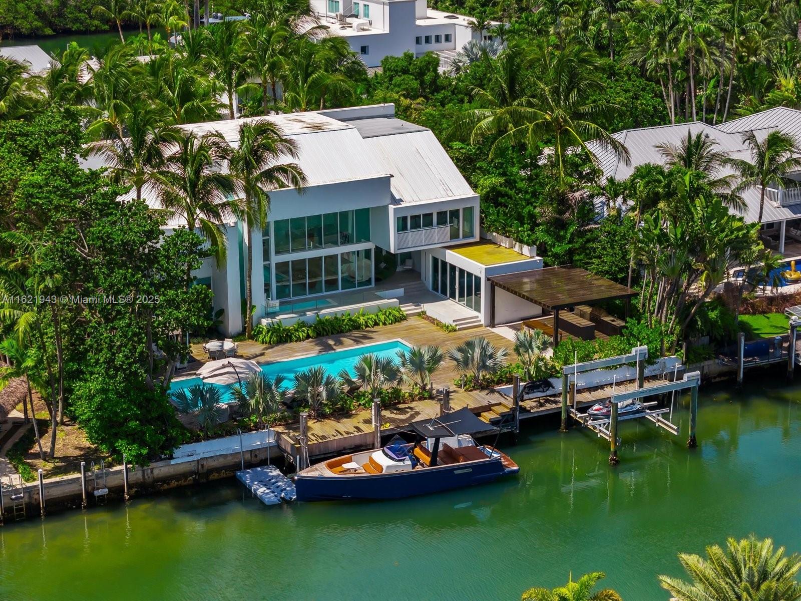 MAJOR PRICE IMPROVEMENT!! Experience luxury living at its finest in this stunning Key Biscayne waterfront home!. Recently renovated to the highest standard, no expense was spared in creating this masterpiece with new bedrooms, bathrooms, flooring, plumbing, electrical, outdoor deck, kitchen, and appliances. Enjoy the spacious, contemporary design with a private oasis and breathtaking canal views. Natural light streams through soaring ceilings and floor-to-ceiling sliding glass doors, while custom lighting adds a touch of sophistication. The home features 4 generous en-suite bedrooms, a gym (convertible to a 5th bedroom), a gorgeous home theater, powder room, cabana bath, and an outdoor summer kitchen with covered lounge space and boat lift. Additional conveniences include 2 service bedrooms!