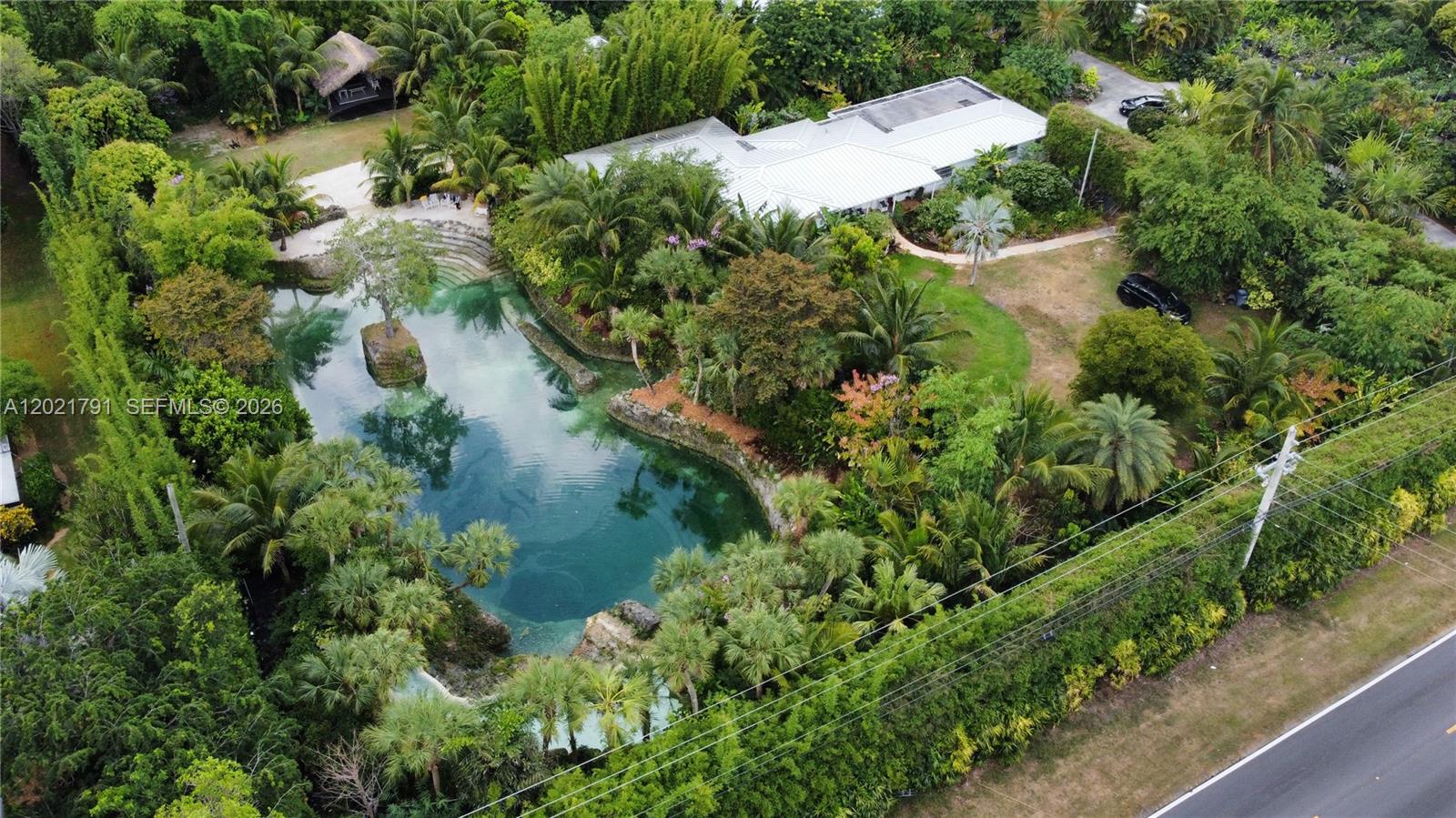 Prepare to be enchanted by this tropical oasis nestled in the heart of the Redlands! 2.76 acres of serene beauty with an immaculately kept grotto, two private 3/2 homes and more! Go for a swim in the breathtaking grotto that features a spacious outdoor seating are, tiki hut, and gorgeous gazebo. Dazzle your guests with live music and entertainment in the amphitheater and stage area. Separate outdoor restroom with A/C and fireplace included. Front house features a 2 car garage, Florida room, and covered patio with an outside kitchen. 2nd house has a 1 car metal carport, tile flooring, addt'l room, and covered patio. This property is a beautiful space for outdoor ceremonies, weddings, photo/film shoots or can serve as your own private piece of tropical paradise. This is a must see!