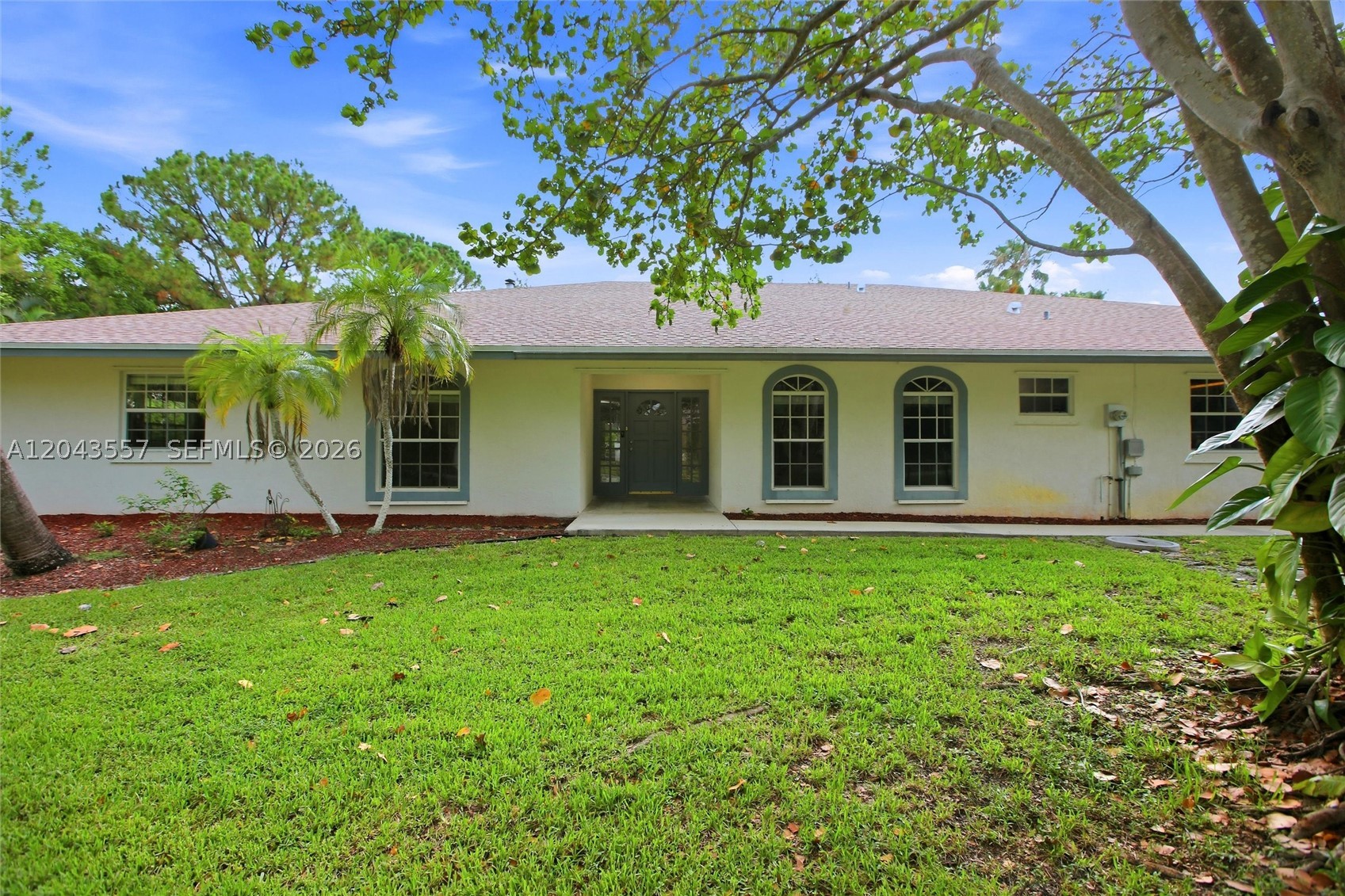 Welcome to your own singe-story tropical retreat with a 6-car garage in a desirable West Palm Beach location! Situated on a HUGE lot over 1-acre with lush green landscaping and mature palm trees, this move-in ready home offers exceptional curb appeal and plenty of room to enjoy the Florida lifestyle. 
Inside, you'll find durable luxury vinyl plank flooring and tile throughout, complemented by fresh interior paint, window blinds and spacious sunroom to enjoy the Florida weather. The inviting living area features a cozy fireplace, while the kitchen boasts white cabinetry, stainless steel appliances, and ample storage. The primary bathroom includes a dual vanity for added convenience. Step outside to enjoy the landscaping with outdoor lighting, creating the perfect setting for relaxing evenings or entertaining guests. The oversized garage provides incredible space for vehicles, hobbies, or additional storage, while the expansive driveway offers abundant parking. Combining comfort, style, and functionality on an oversized lot in one of West Palm Beach's most desirable areas, this is an opportunity you won't want to miss!