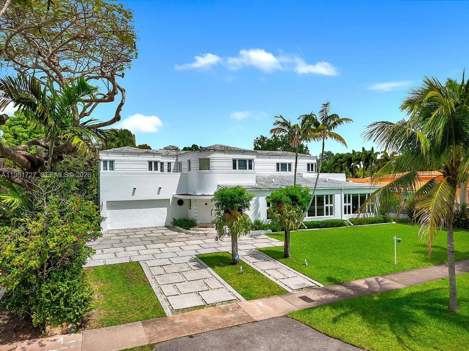 Welcome to a rare 1937 Art Deco Streamline Moderne masterpiece in the prestigious City of Coral Gables, perfectly positioned across from the Granada Golf Course. Recognized on the Coral Gables Registry of Historic Places, this architecturally significant residence was designed by William H. Merriam—celebrated for his Moderne and Mediterranean works—and beautifully blends historic pedigree with timeless Coral Gables charm.
A gracious round foyer with original terrazzo floors introduces the home and leads to the formal living room with  fireplace and an inviting library, both showcasing the craftsmanship of the era. The first level offers 2 bedrooms and 2 full baths plus a guest bath, along with formal living and dining rooms, a library, family room, and a billiard room, providing exceptional spaces for both everyday living and entertaining. The original curved staircase, a hallmark of Streamline Moderne design, guides you to the second floor, where you’ll find 4 additional bedrooms and 3 bathrooms, including the main suite, as well as a charming children’s den. Expanded over the years yet rich with preserved architectural details, this home is a rare opportunity to own a piece of Coral Gables history in an iconic setting.